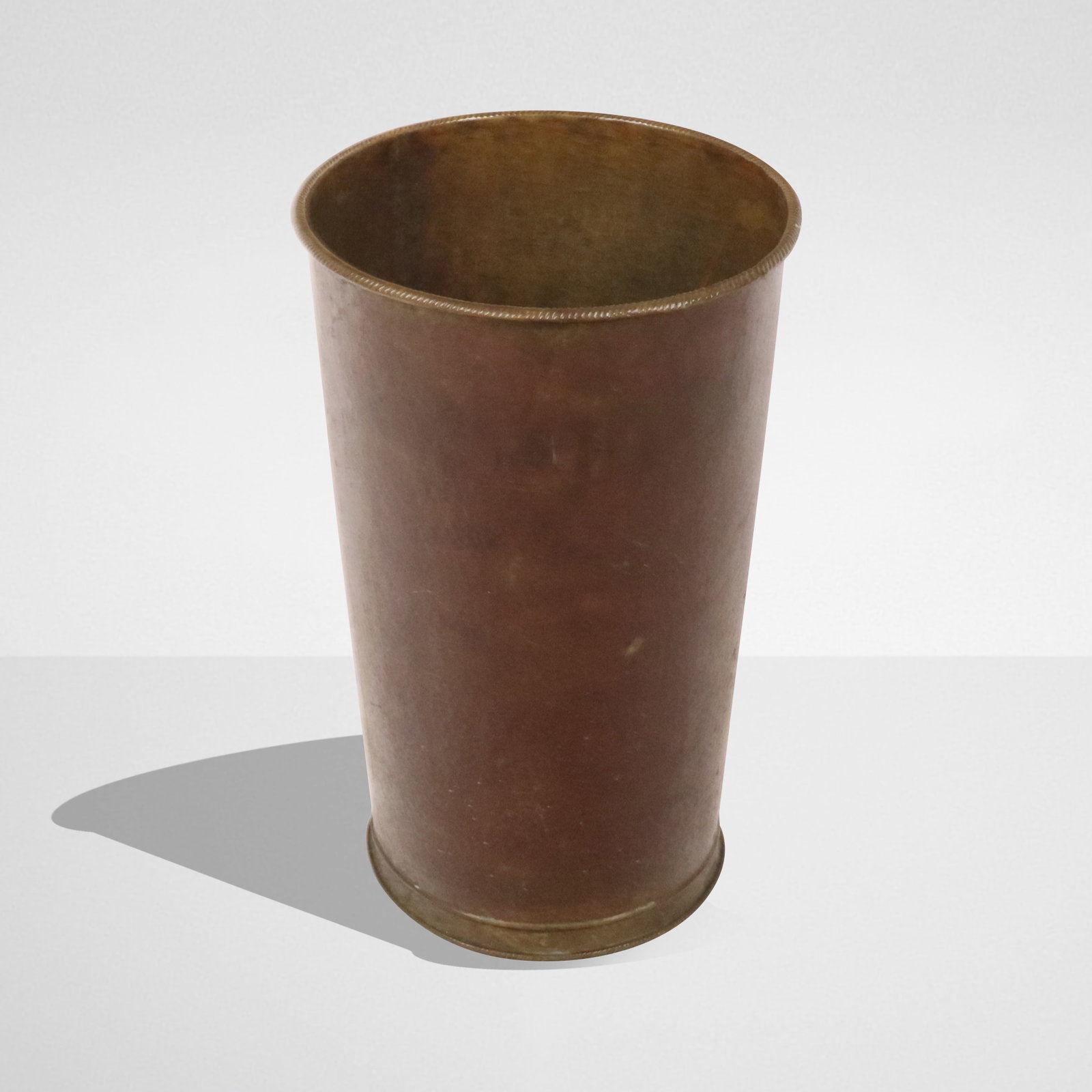 Hammered Copper Umbrella Stand: Hammered copper umbrella stand, Italian, 20th century, with a hammered copper body and brass rope twist detail to upper rim, with Made in Italy label to base. [19" H x 12" Diameter]. Condition is good