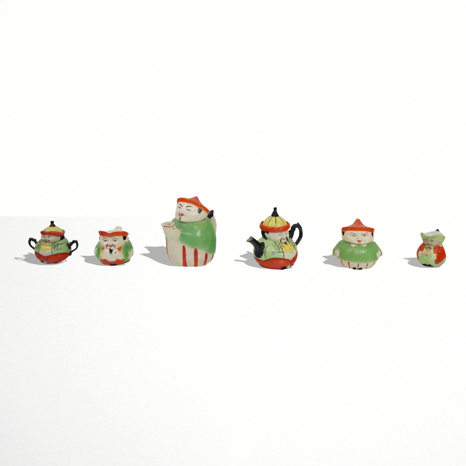 German Porcelain Figural Tea Set, 6 pieces: Collectable German porcelain tea set, Each piece an Asian man with green jacket, 2 teapots, 2 creamers, 2 covered sugars. [Taller teapot 7"]. Good condition.