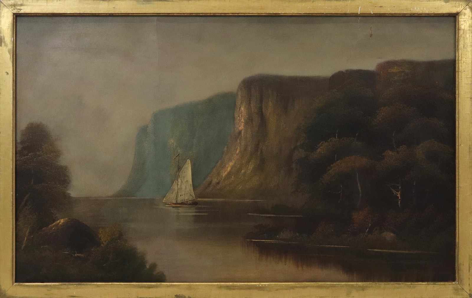 19th/20th Century Oil/Canvas Rocky Coast Landscape: Late 19th-early 20th century oil on canvas, rocky coastal river landscape with sailboat, framed. [Canvas: 22" H x 36" W; Frame: 24" H x 38" W]. Wear commensurate with age, several repairs and puncture