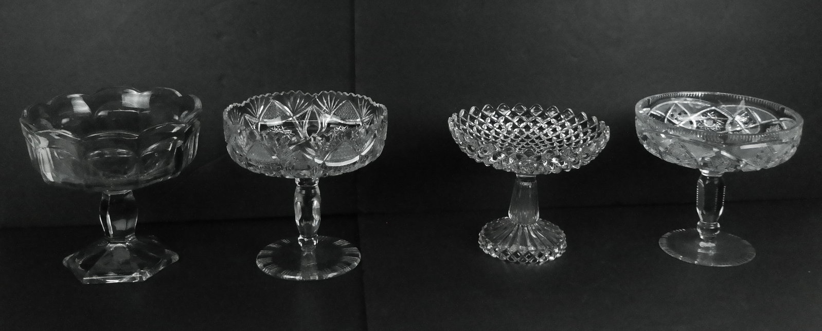 Two Crystal and Two Pressed Glass Compotes: Two crystal and two glass compotes, 20th century, comprising two similar cut crystal compotes, each unmarked, and two later pressed glass compotes, each unmarked. [Tallest: 8" H x 8.25" Diameter]. Con