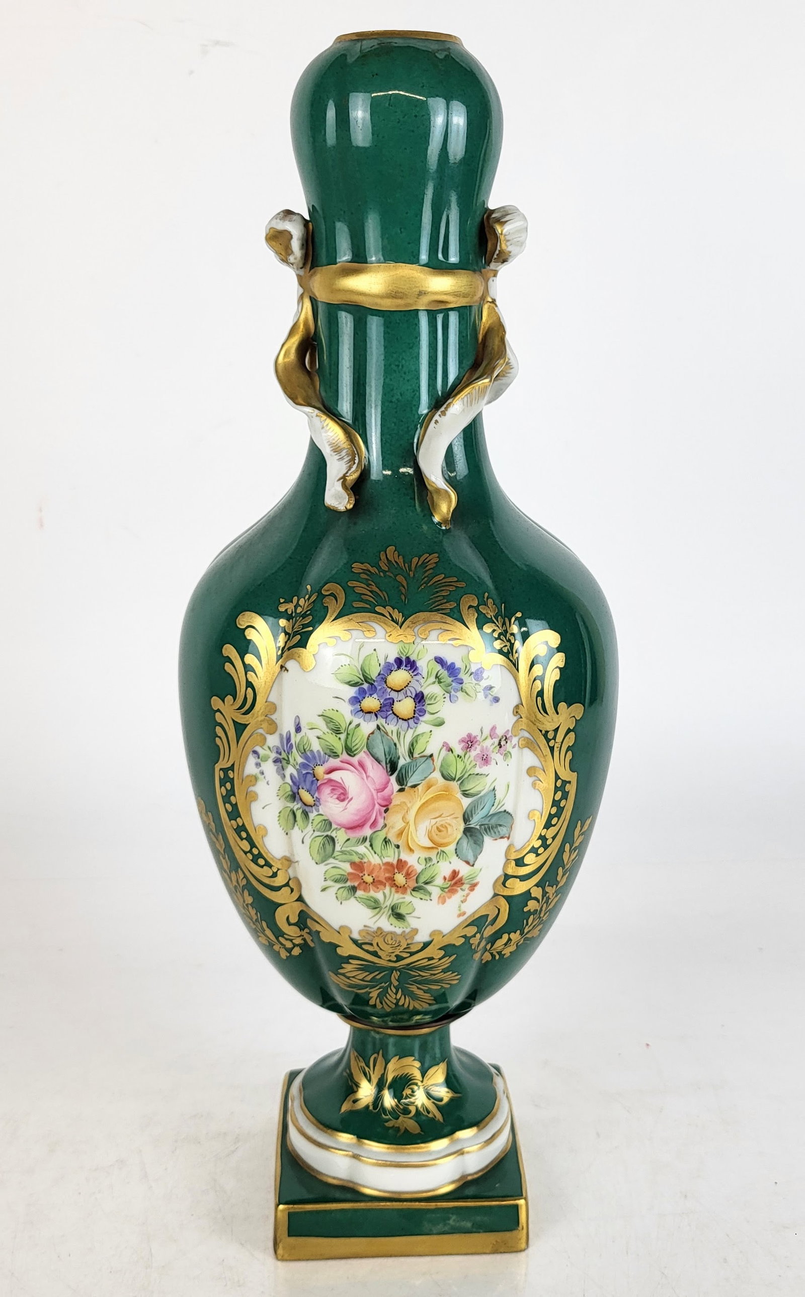 Porcelain de Paris Hand-Painted Green Vase: Porcelaine de Paris hand-painted green vase, French, probably 20th century, in a baluster form with gilt ribbon shaped handles, gilt decoration throughout, and a hand-painted cartouche depicting a flo