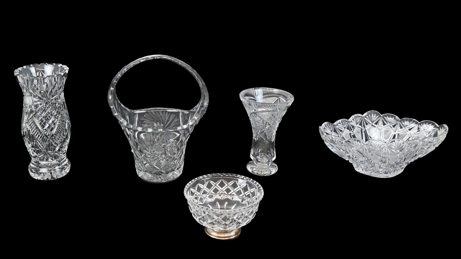 5 Cut Crystal & Glass Articles: Group of cut crystal and glass articles, 20th century, comprising a bowl, two vases, a basket, and a condiment with sterling silver base. [Larger serving dish: 5.5" H x 12" W x 6" D]. Condition is goo