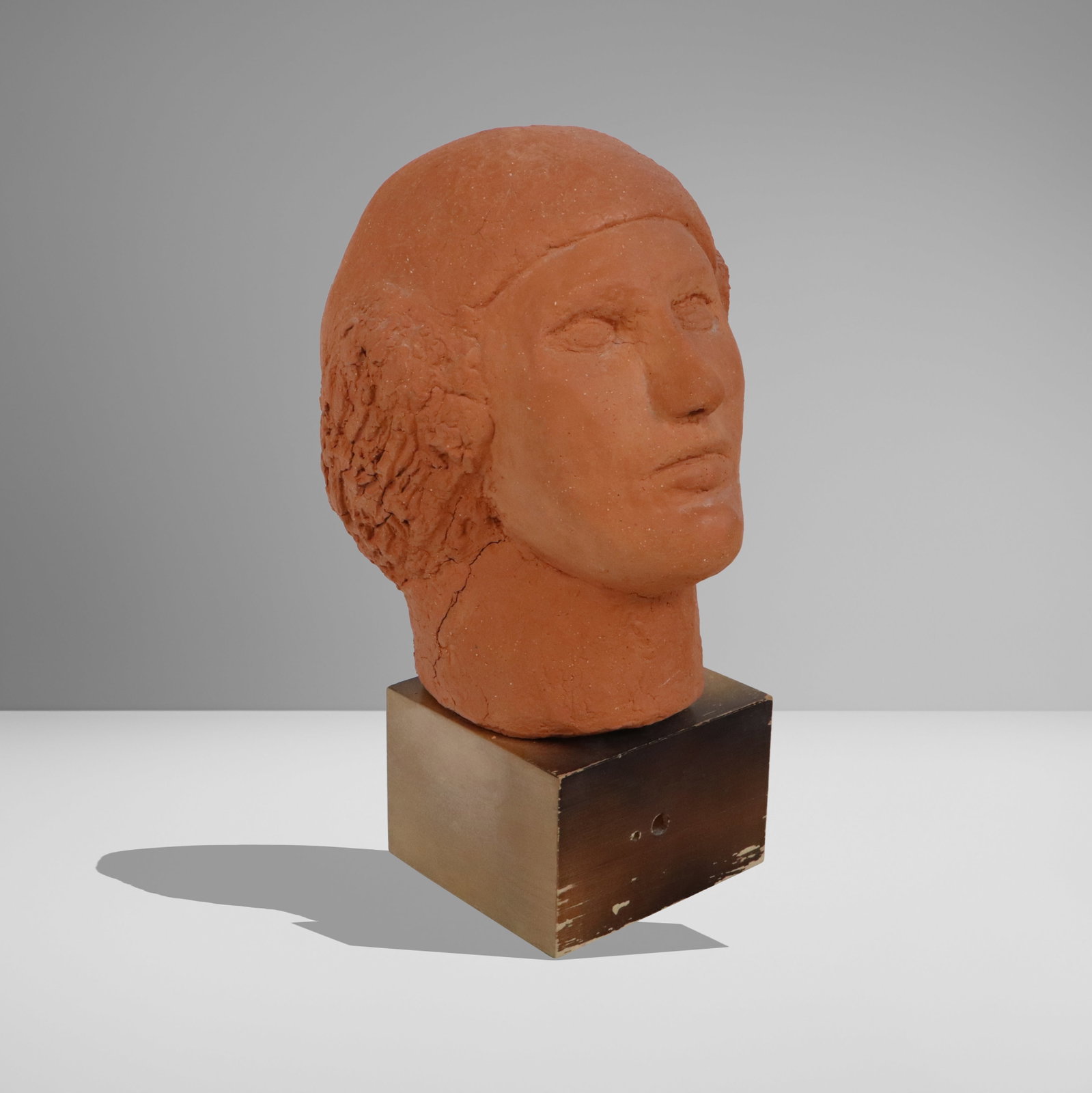 Terra Cotta Head on Stand: Terra cotta head on stand, 20th century, apparently unsigned. [13" H x 9.5" W x 9" D]. Condition is good to fair with cracks and repairs to lower reverse.
