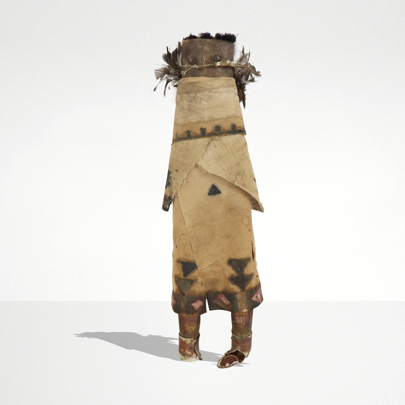 Zuni Kachina Doll: Zuni Kachina doll, American, 19th century, with wood construction and mounted with hand decorated cloth with feather detail, horse hair to upper, and leather at feet. [15" H x 5" W x 2" D]. Condition 