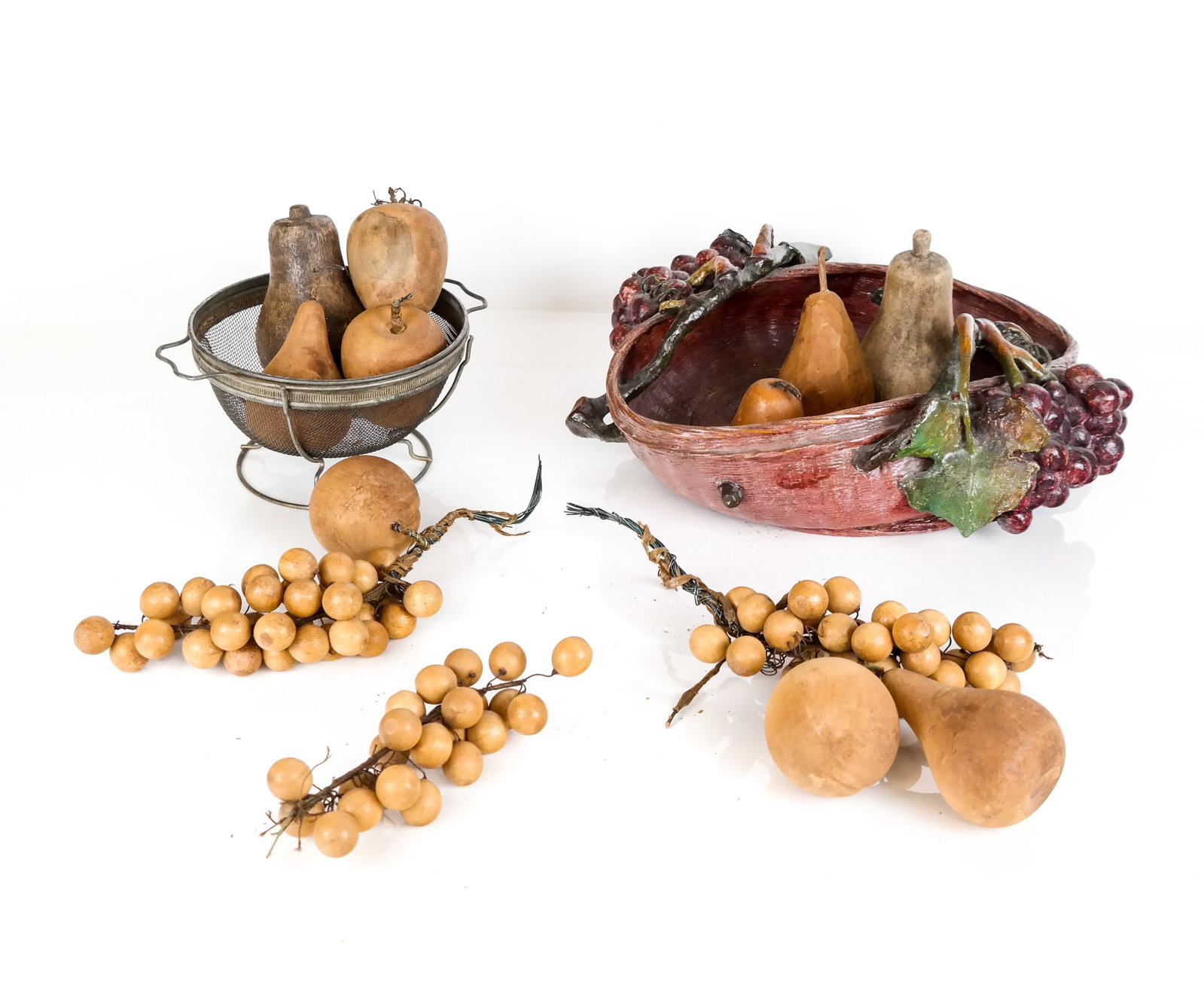 Arts & Crafts Painted Basket & Wood Fruit: Arts & Crafts woven basket having mounted paper mache grape clusters entwined in the basket sides, the basket filled with carved wood grapes, pears and apples. [Basket: 6" H x 15" W x 14" D]. From the