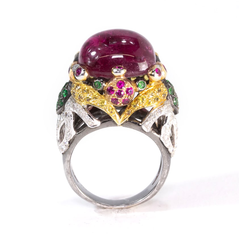 Rubellite, Diamond, Gem-Set & Gold Ring: Cabochon rubellite, diamond, ruby, amd garnet ring, centered by a cabochon rubellite, 16.2 x 13.9 x 17mm, embellished with small round assorted gemstones, marked 750. [13.09 dwt., Ring size: 8.5]. Ove