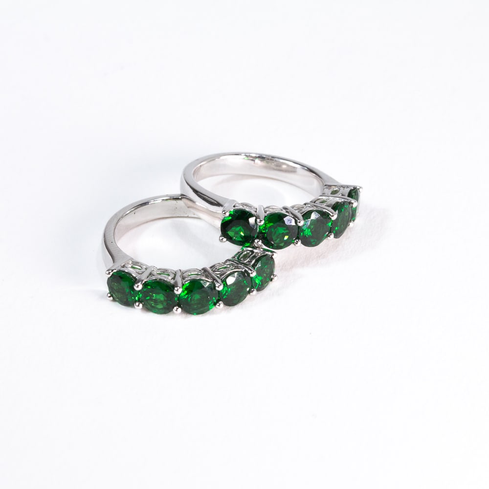 Pair of Green Garnet & White Gold Stack Rings: Pair of green garnet and white gold stack rings, prong-set at the top with round garnets, total approximately 2.00 cts., marked 18K. [Total 7.54 dwt., Ring size: 6]. Overall condition is good, garnets