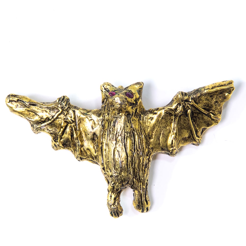 Ailene Fields Gilded Bronze Bat Pendant: Ailene Fields sculptued bronze bat pendant with gold patina, accentedFrom the esteemed collection of Neil Zukerman former owner of CFM Gallery. with ruby eyes, signed with artist's monograme on revers