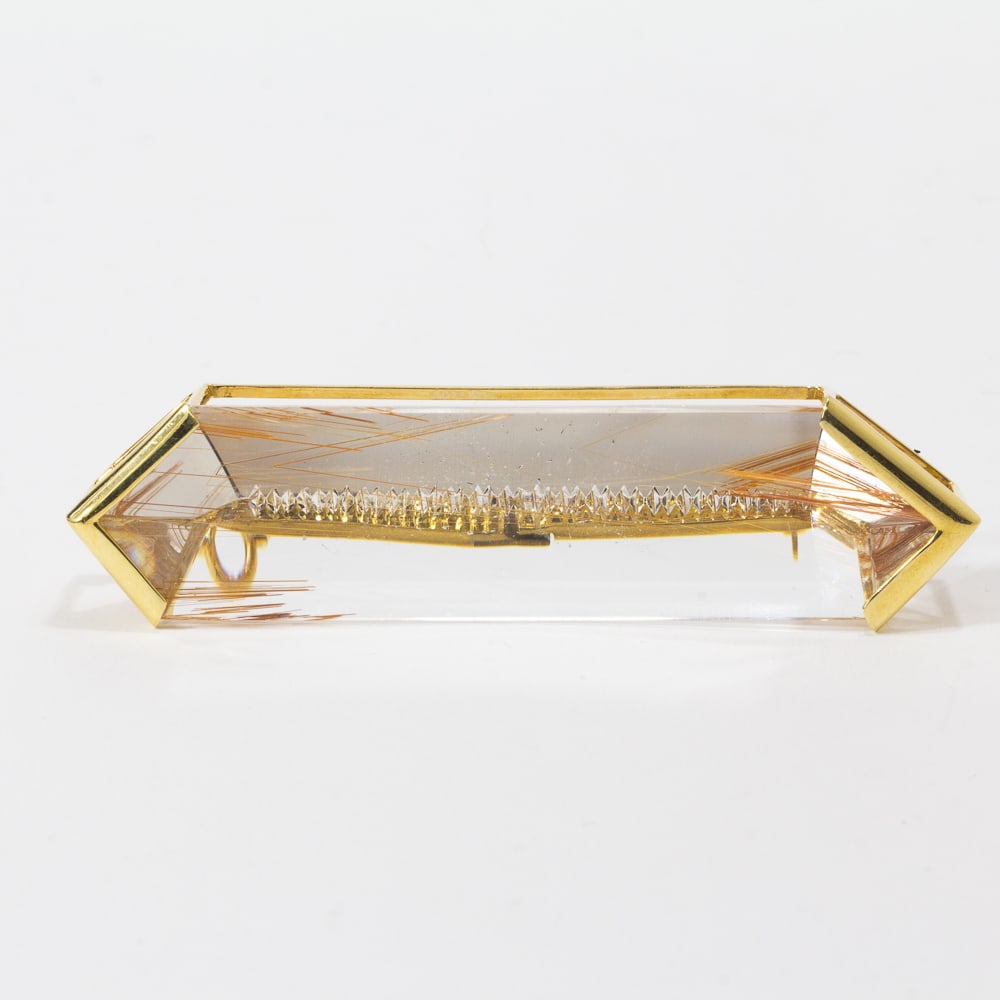 Rutilated Quartz & Gold Penant Brooch: Moderist rutilated quartz and gold pendant brooch, signed 18K AK, with retractible pendant loop. [3.25" H x .75" W]. Overall condition is good, modification evident on the reverse. Overall condition i