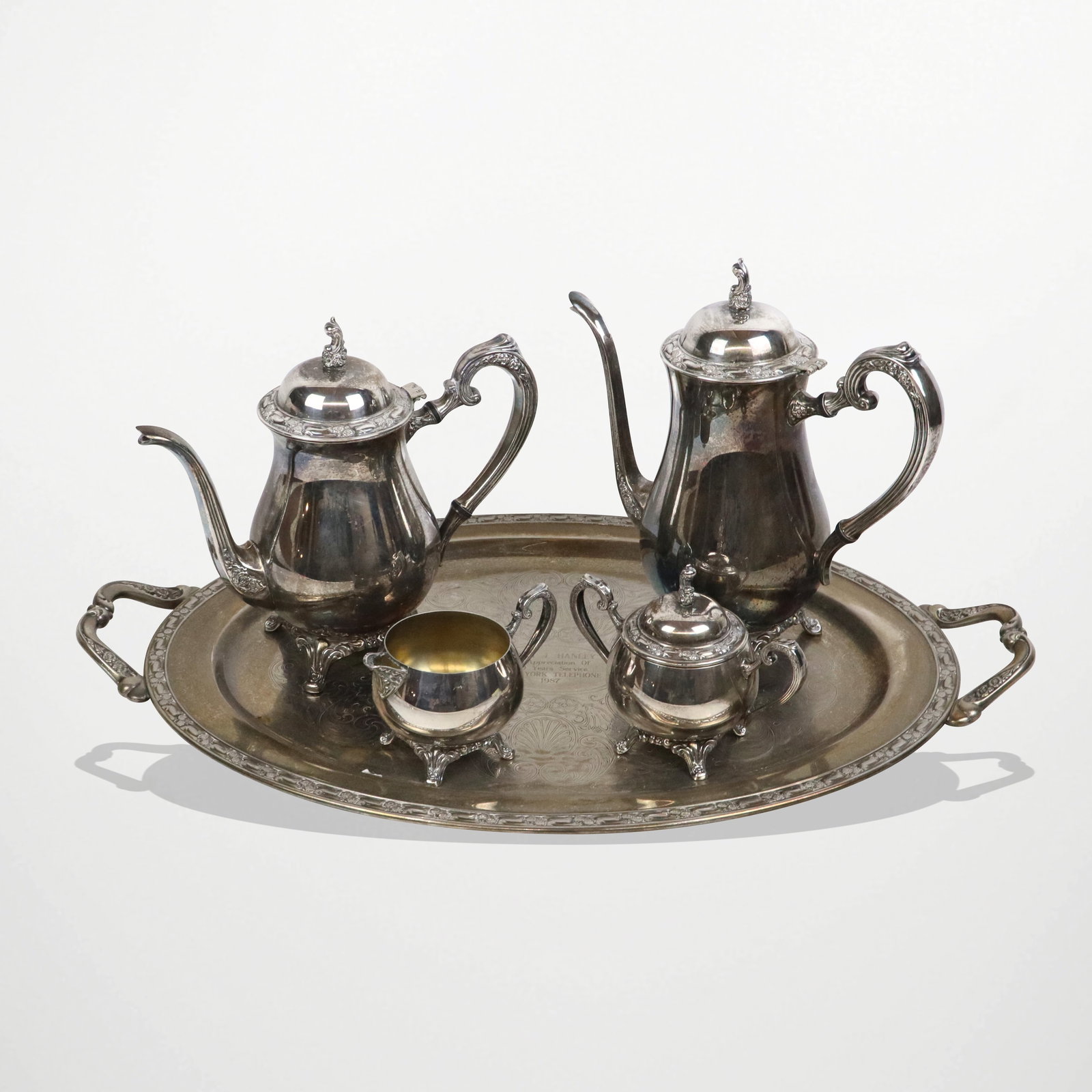 Oneida Silver Plate Coffee Set with Tray, 5: Oneida silveer plate tea and coffee service with engraved two handled tray, comprising teapot, coffee pot, creamer and covered sugar, mark to reverse. [Tray: 24" L x 14.5" W]. Overall condition is goo