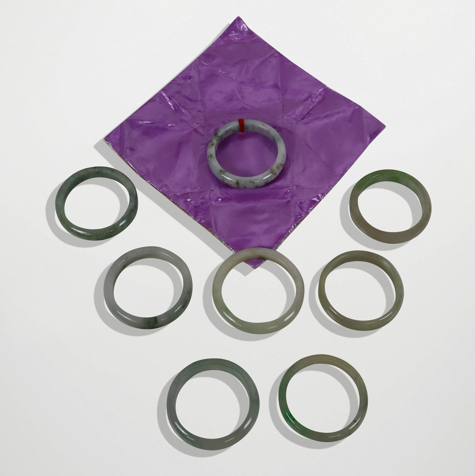 Eight Jade Bangles: Eight jade bangles, China, 21st century, in various tones. [Larger: 3.25" exterior diameter; 2.5" interior diameter]. Condition to each is good, not tested for impregnation.