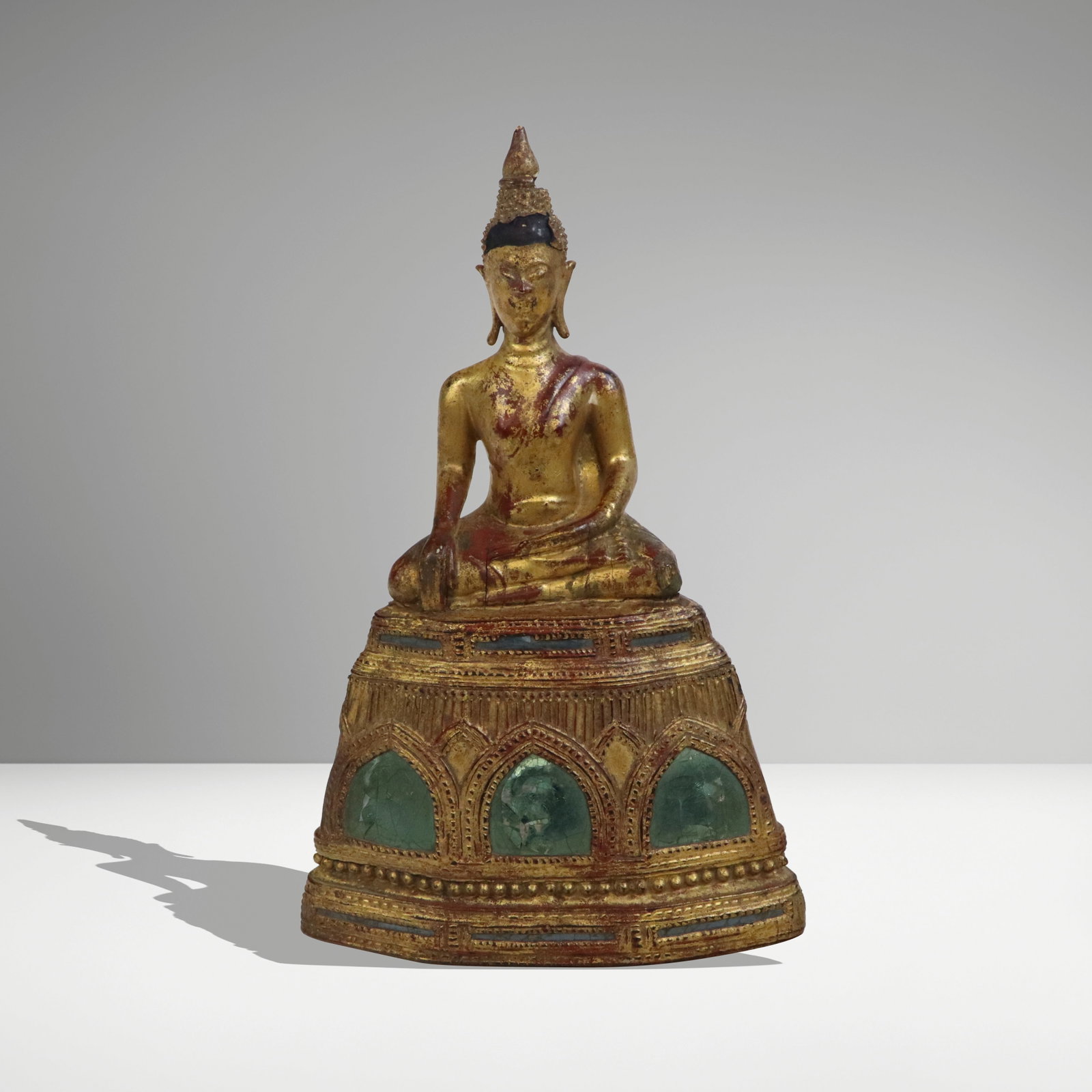 Thai Carved and Lacquered Wood Buddha: Thai carved and lacquered wood figure of Buddha, 20th century, in lotus pose with an affixed base with mirrored decoration. [8.5" H x 6" W x 4" D]. Condition is good with losses to headpiece and crack