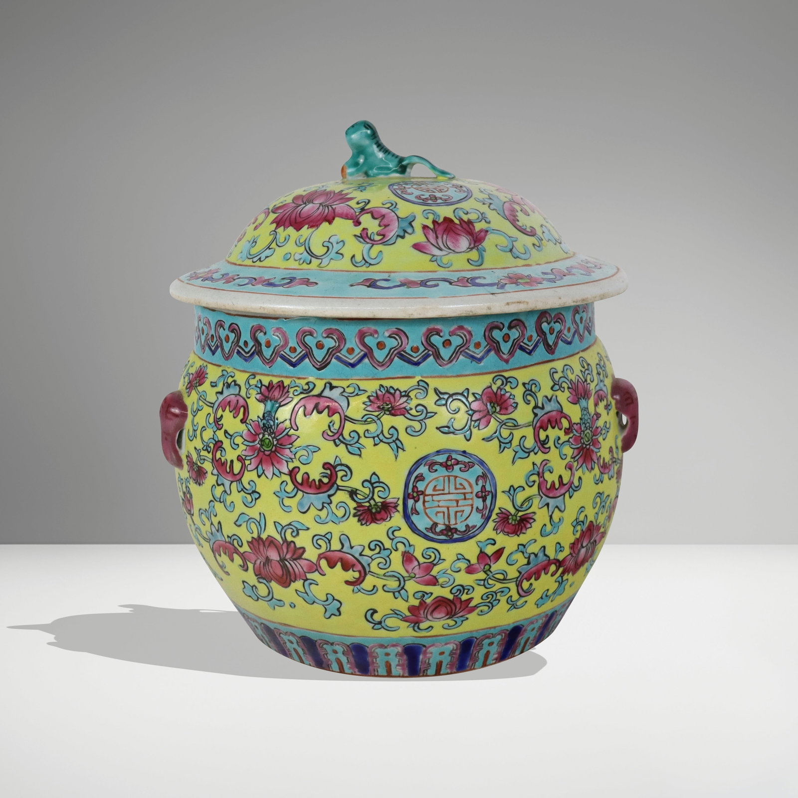 Chinese Famile Rose Porcelain Covered Jar: Chinese famile rose porcelain covered jar, the top with turquoise painted tiger finial, the yellow and turquoise-banded group with pink lotus blossoms and pink nobs for wire handles, mark to base. [9"