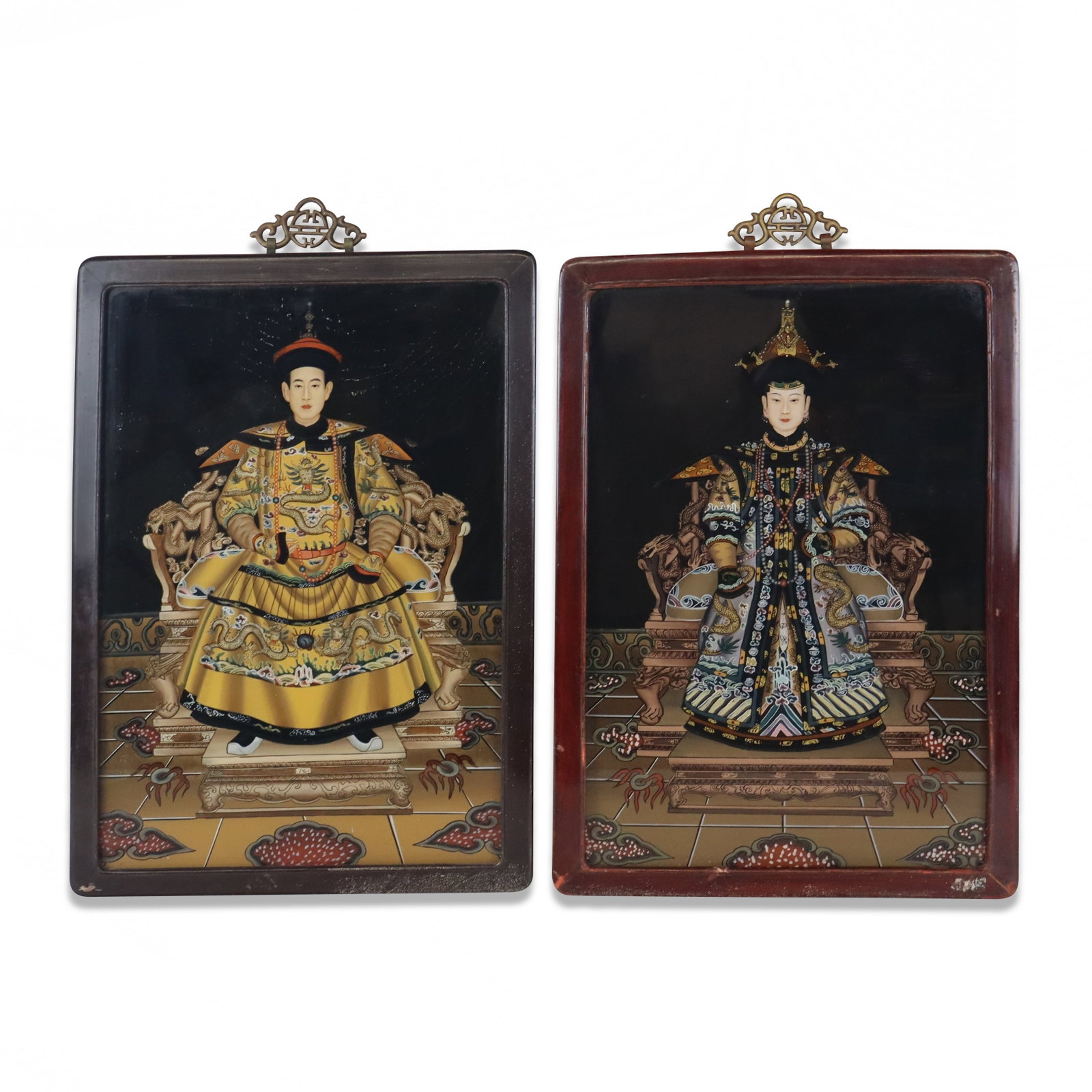 Pair Chinese Reverse Painted Ancestral Paintings: Pair of Chinese reverse painted glass ancestral paintings, 20th century, including a figure of a man and of a woman, each in frames. [Framed: 21" H x 14" W]. Condition is good.