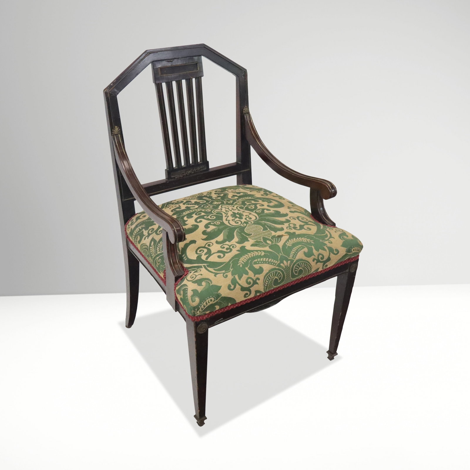 Antique Russian Mahogany Upholstered Armchair: Antique Russian mahogany upholstered armchair, late 19th century, the mahogany frame with brass line inlays and mounts, having green and gold scrolling foliate pattern upholstery with deep red trim. [