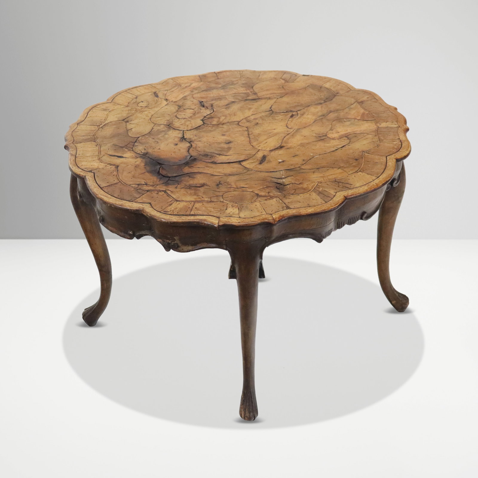 Louis XV Olive Wood Low or Center Table: Louis XV low or center table, 20th century, with an olive wood top over four cabriole legs. [20" H x 27.5" Diameter]. Condition is good with lifting to olive wood veneer at tip and minor scuffing at l