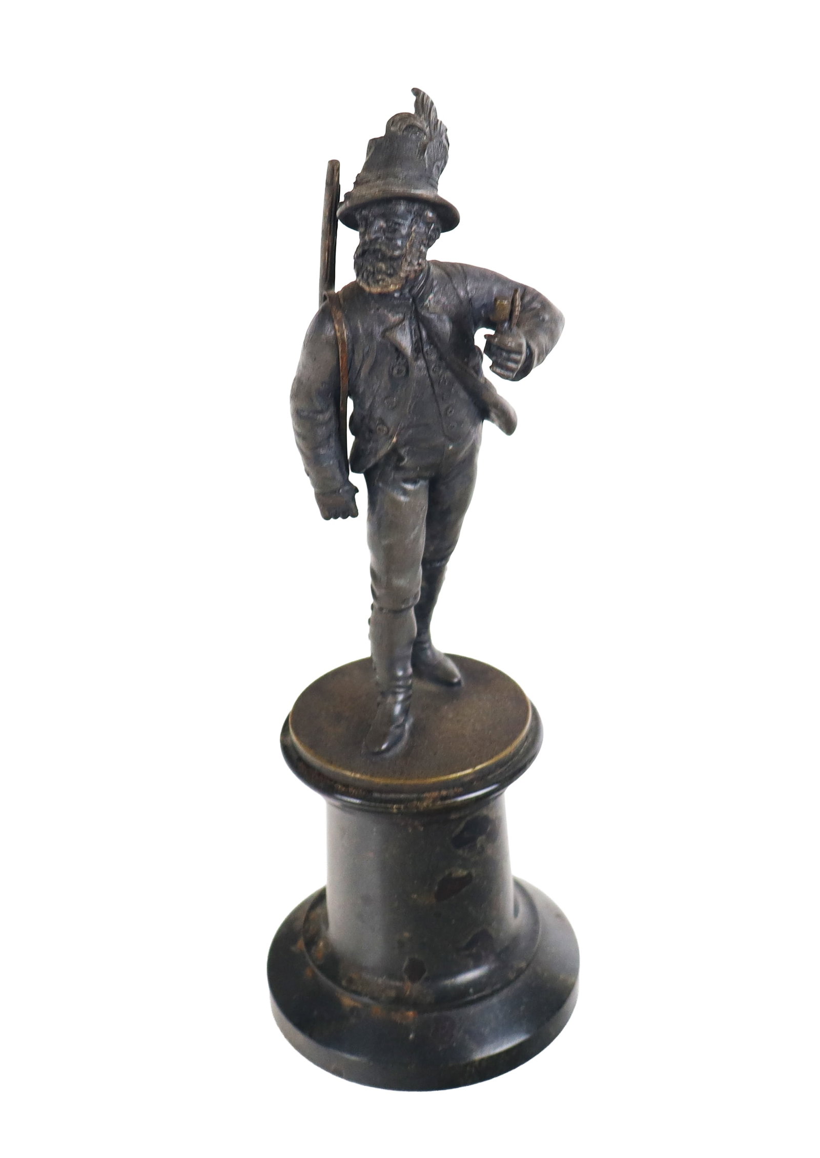 Bronze Figure of an Alpine Hiker: Small bronze figure of an Alpine figure with feathered hat, rifle, and ruskack, resting on a marble columnar stand. [7.5" H x 2.5" Diameter].. Overall condition is good, with some residue to base.