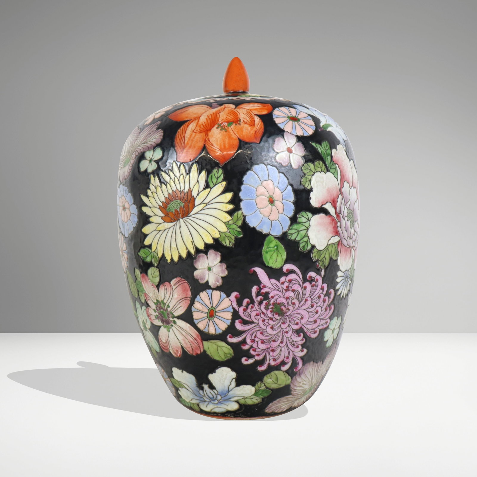 Chinese Famille Noir Ginger Jar on Stand: Chinese export famille noir ginger jar, 20th century, with hand-applied floral decoration, and with a stamped mark to base, on a wooden stand. [Less stand: 14.5" H x 9.5" Diameter]. Condition is good 