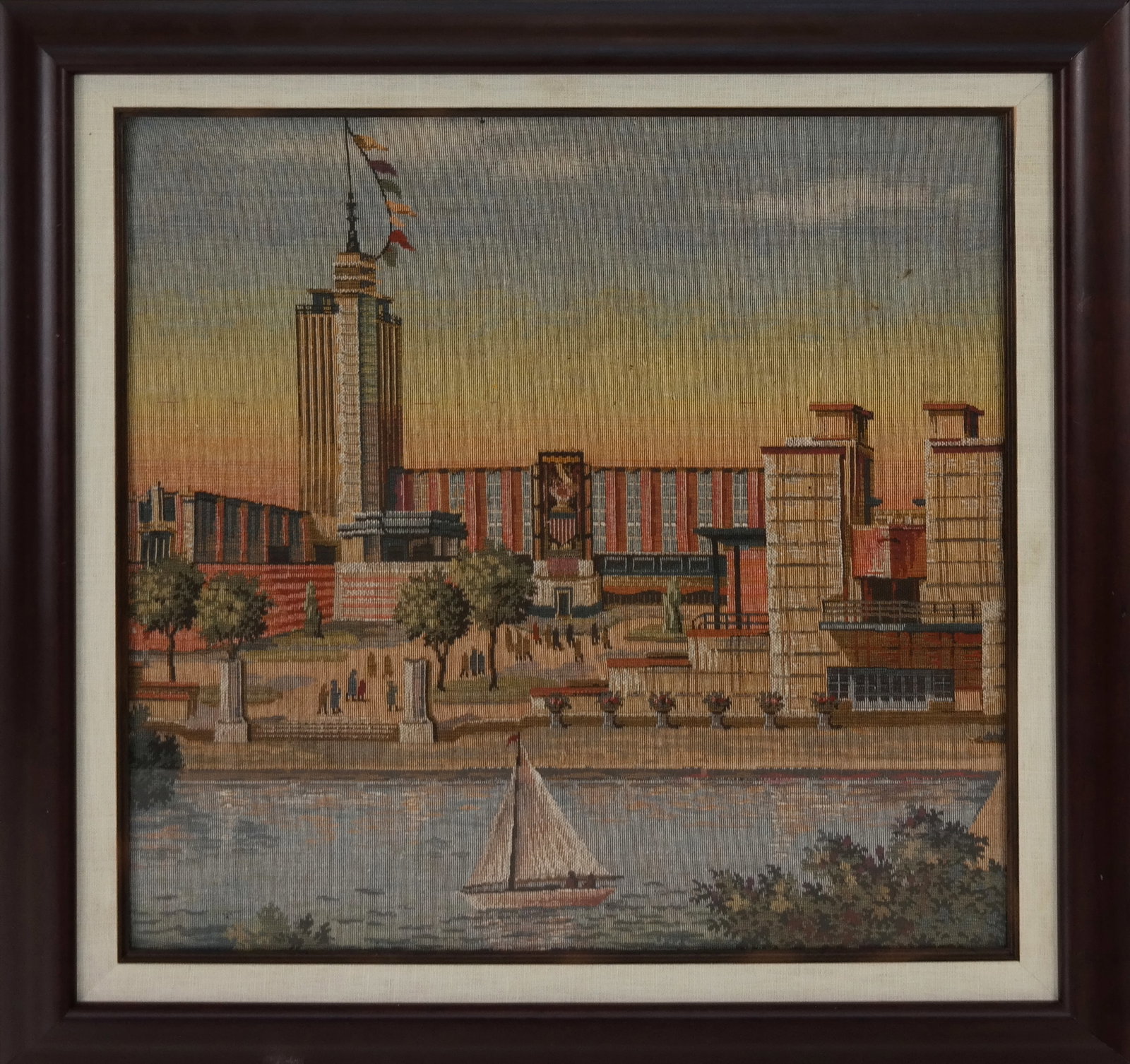 Machine Needlepoint Picture of US Buildings: Machine needlepoint picture of US buildings, on a river with a sailboat. [18" square; 23" square]. Good condition. LOCATED AT 150