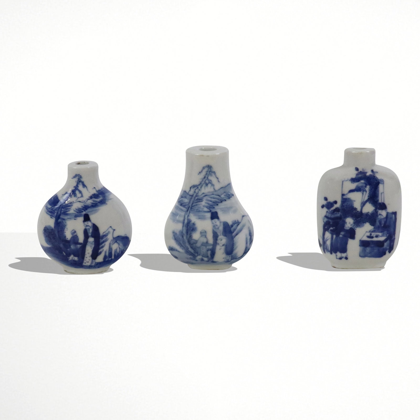 Three Blue and White Porcelain Snuff Bottles: Three blue and white decorated snuff bottles, China, 20th century, each marked to base. [3.5" H x 2.25" W x 1.25" D]. Condition to each is good, all without stoppers.