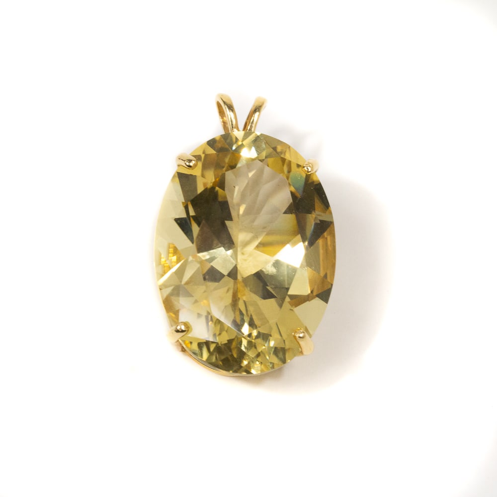 Oval Quartz & Gold Pendant: Oval-shaped lemon quartz pendant, quartz approximately 22 x 27 x 15mm, marked 14K. [2,5" H x 1" W including bail]. Overall condition is good, yellow/brown. From the esteemed collection of Neil Zukerma