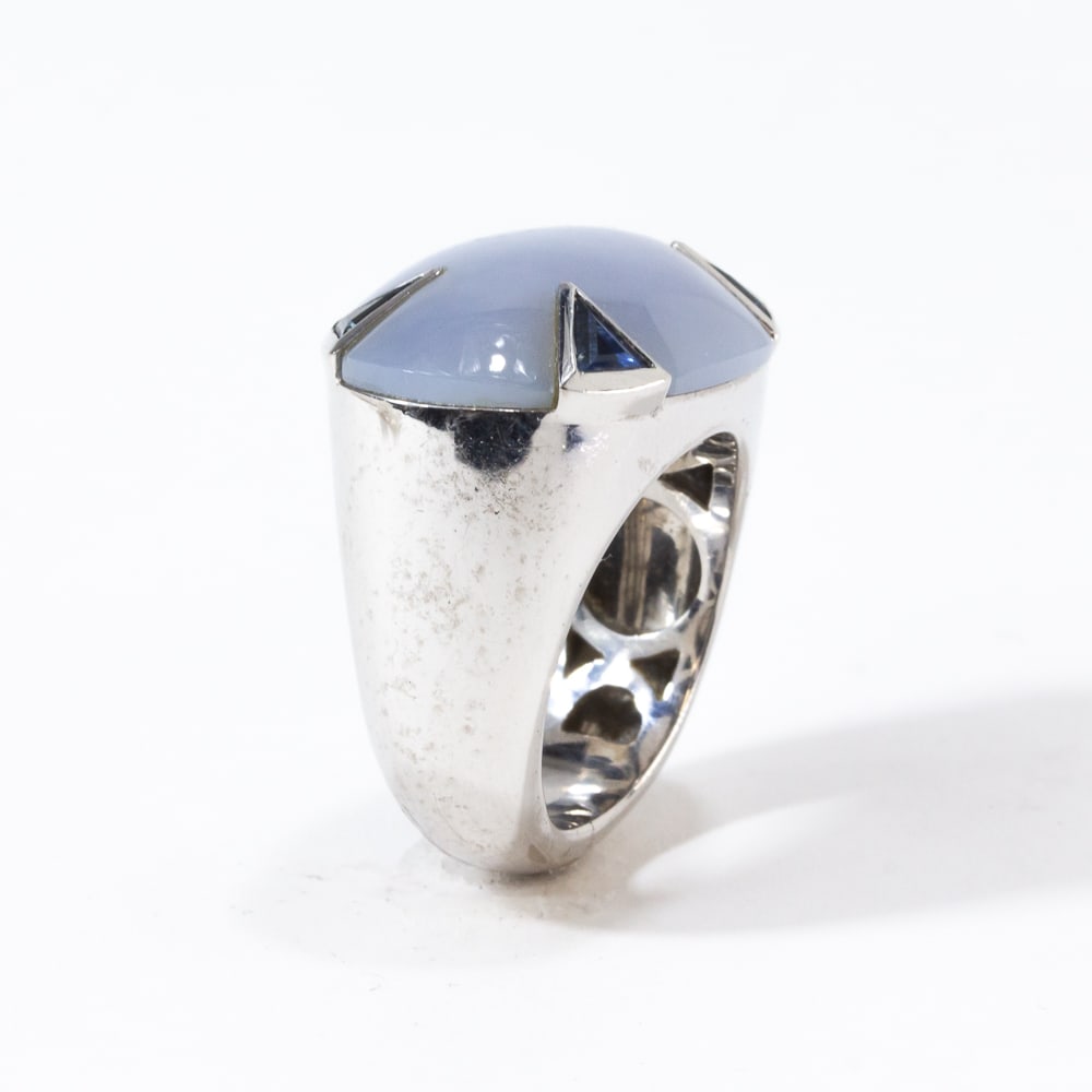 Att. Emil Becker Chalcedony, Sapphire & Gold Ring: Attributed to Emil Becker chalcedony, sapphire and white gold ring, the oval cabochon chalcedony, approximately 24 x 15.5mm, retained by collect-set triangular-cut sapphire prongs, marked on the exter