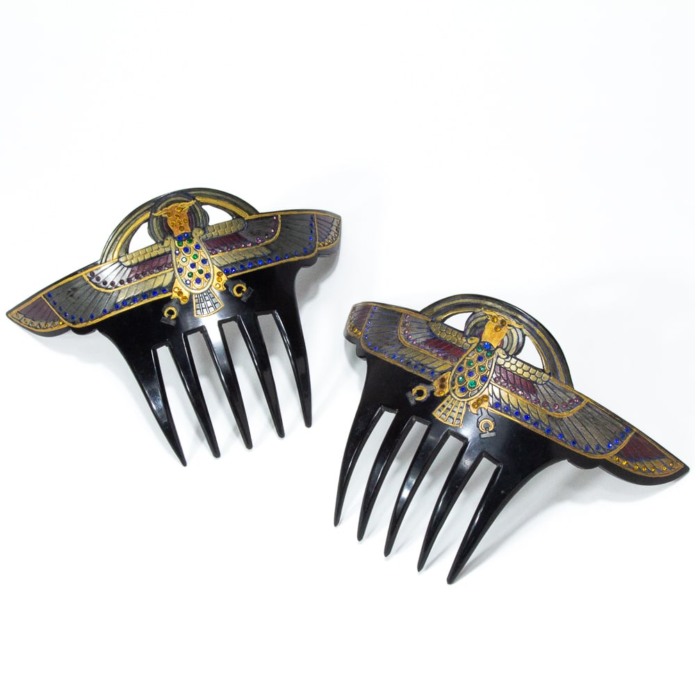 Pair of Egyptian Revival Winged Scarab Hair Combs: Pair of Egyptian Revival winged scarab hair combs, probably American, 1920s, decorated with faux jewels in shades of red, pewter, blue, and green. [4" H x 6" W]. Overall condition is good, with wear c