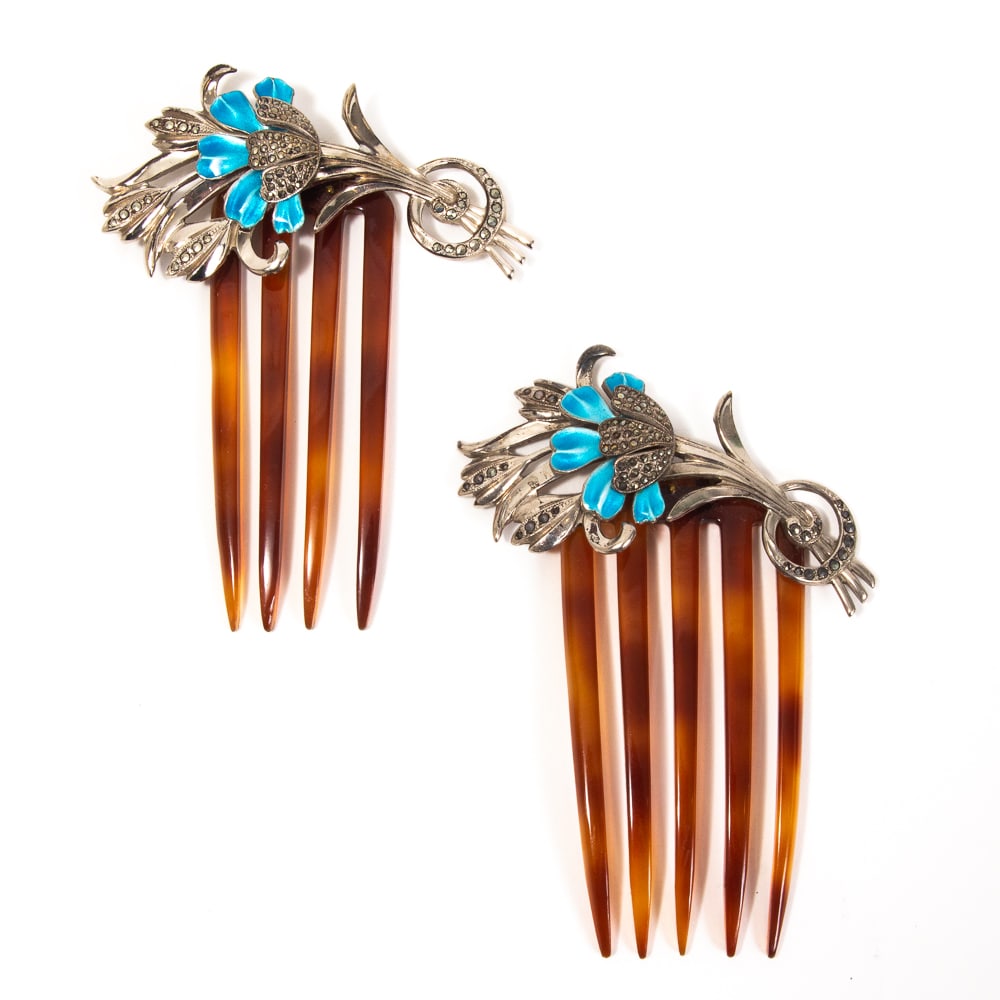 Pair of Silver Enamel Marcasite Flower Combs: Matched pair of sterling silver enamel marcasite flower combs, 1920-40s, comprising a five tine and a four tine comb, the elaborate floral sprays layered with petals of blue enamel and adorned with ma