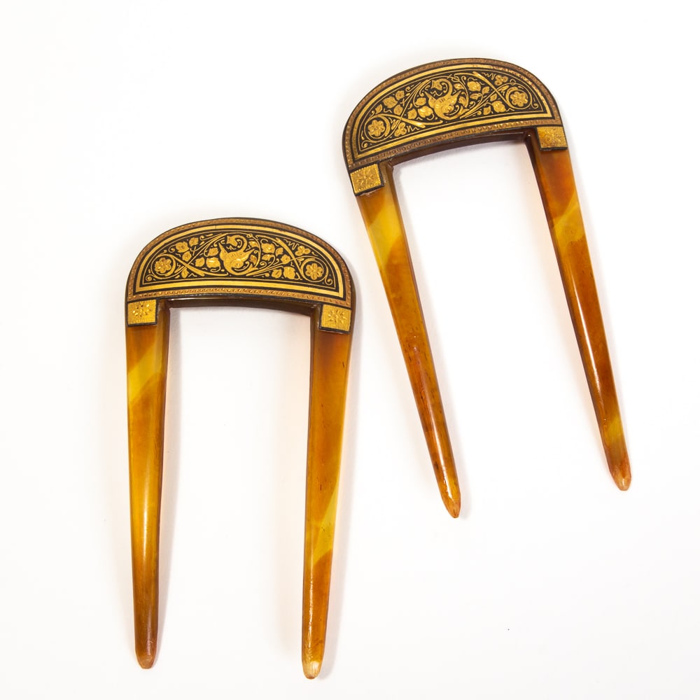 Pair of Victorian Damascene Hairpins: Pair of Victorian damascene hairpins, probably English, late 19th-early 20th century, the two tine pins with damascene inlays of foliage and a central wyvern. [3.75" H x 2" W]. Overall condition is go