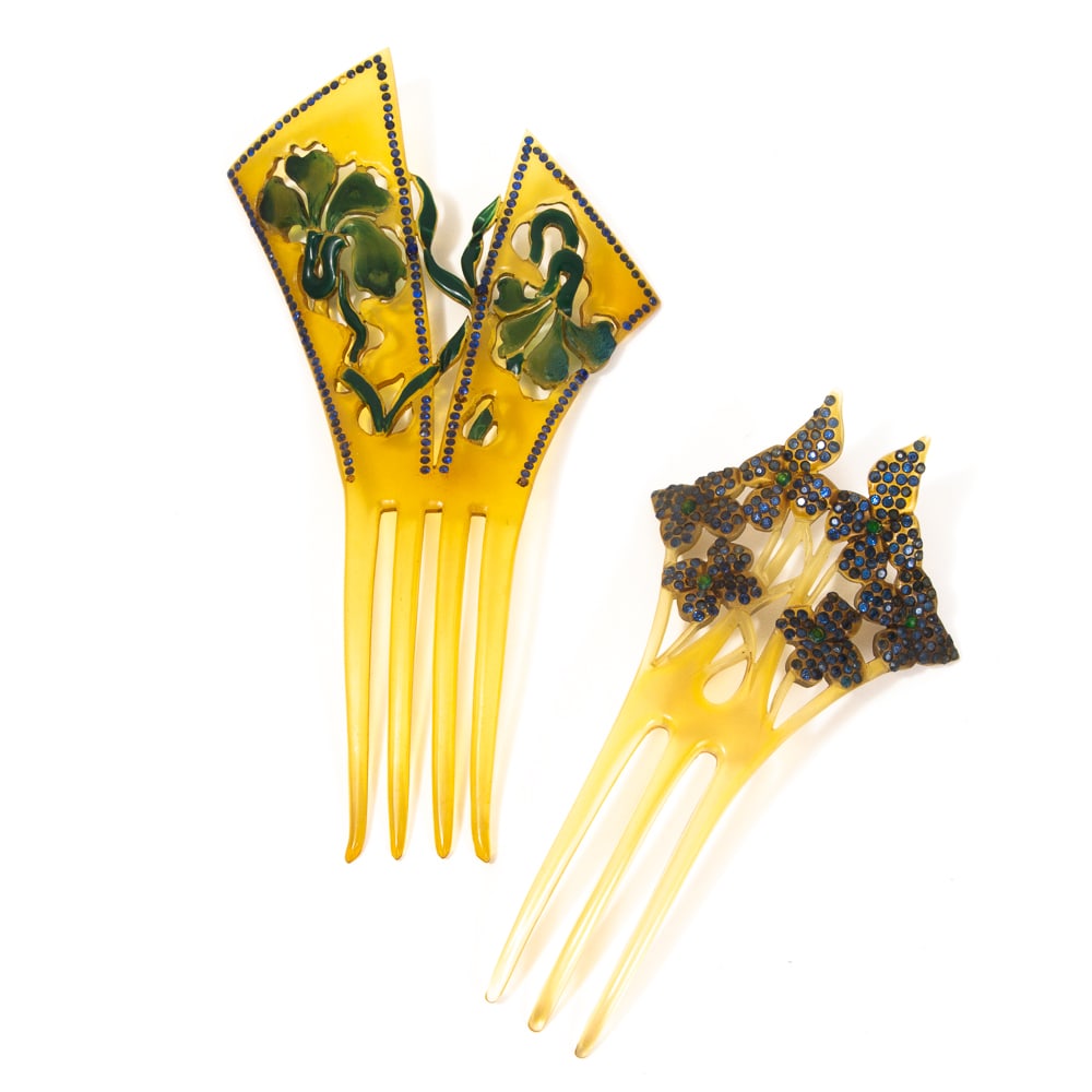Two Art Nouveau Celluloid & Faux Jewel Hair Combs: Two Art Nouveau pierced celluloid and faux jewel hair combs, late 19th-early 20th century, in shades of blue and of elongated outline, each depicting sinuous floral motifs. [Largest: 7" H x 4" W]. Som