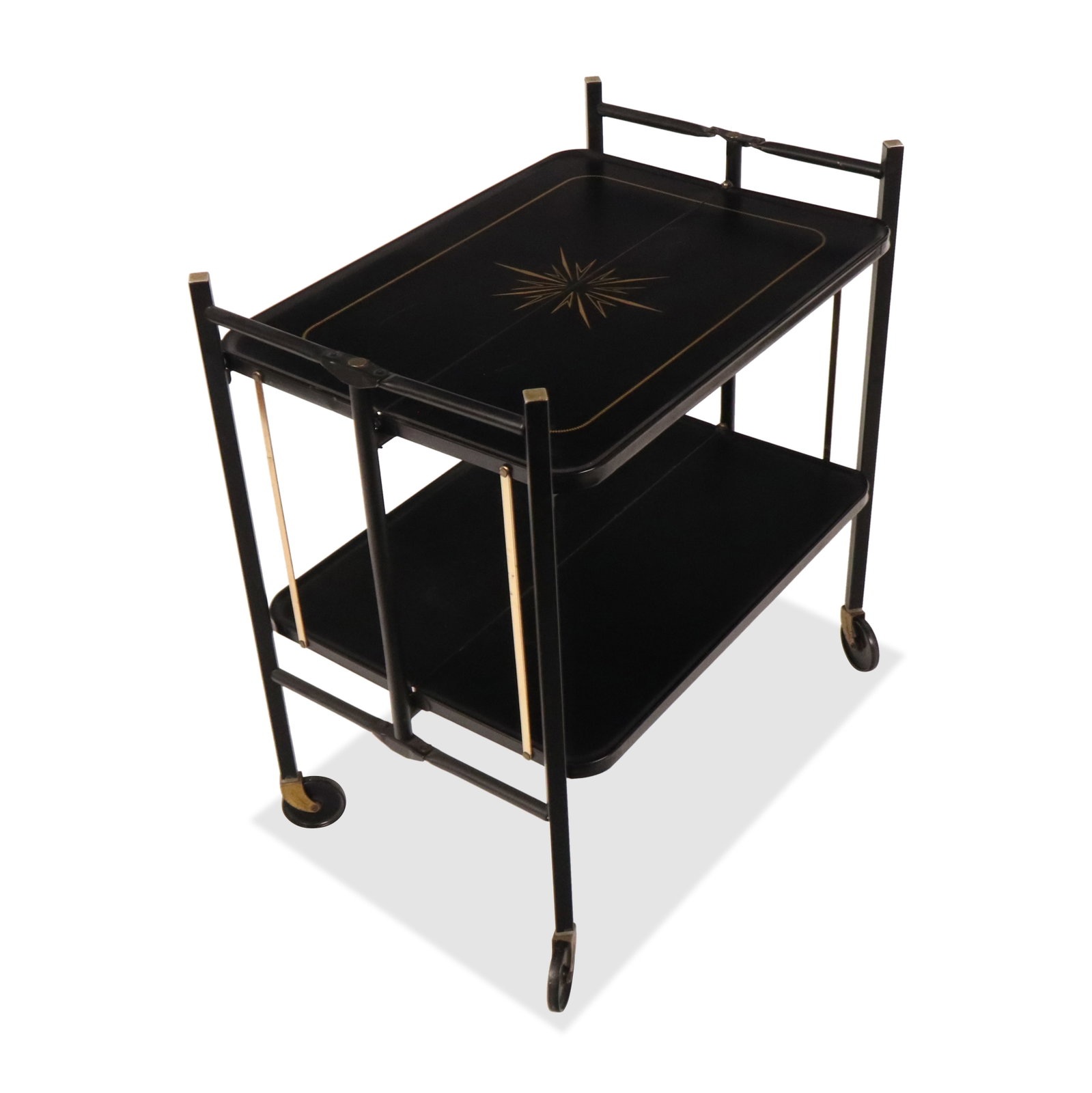Relyon Painted Tin Folding Tea Cart: Relyon painted tin folding bar cart, 20th century, with diamond and sunburst decoration to upper, two tiers, and swing out legs on casters, marked Reyon Products Corp to label at underside. [Collapsed