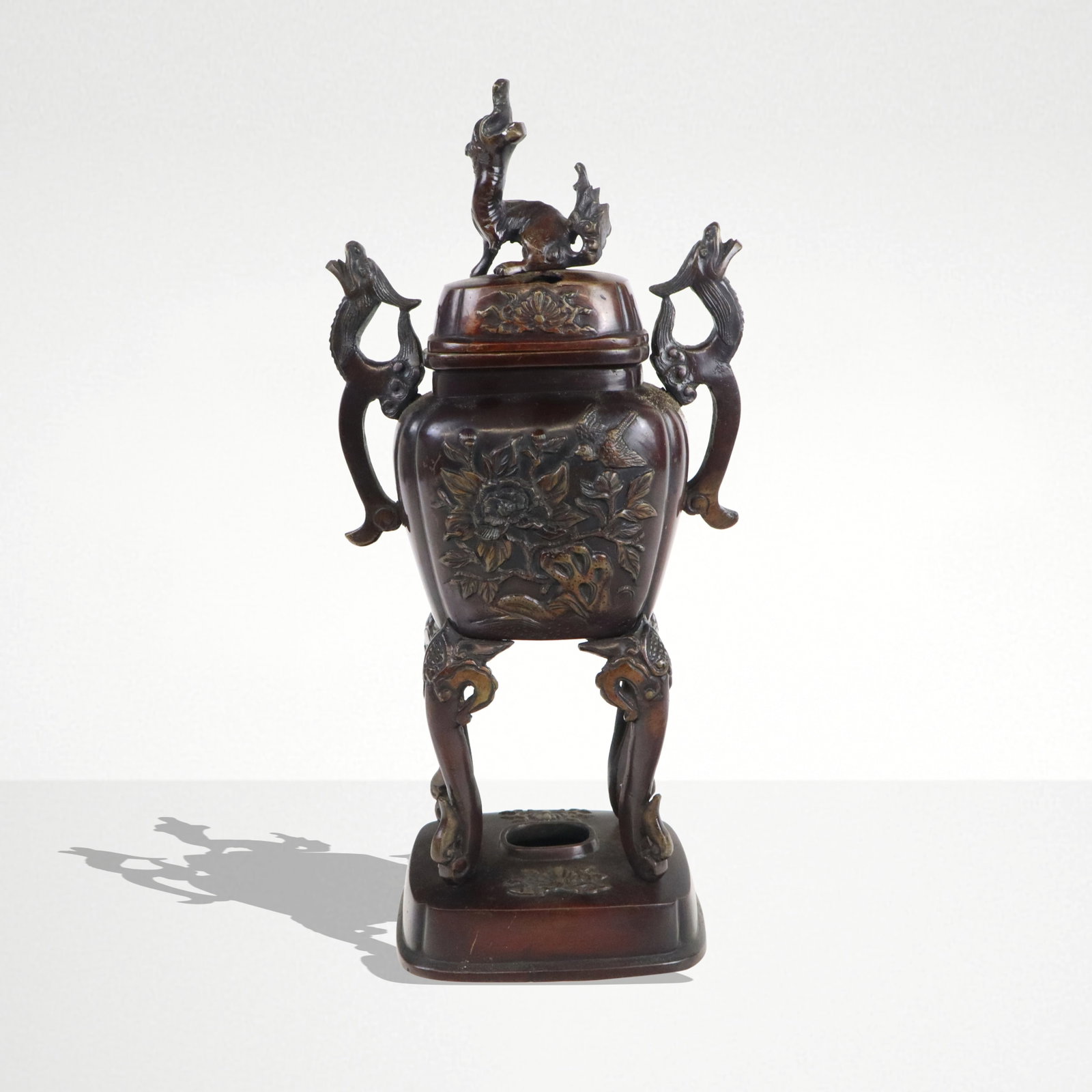 Japanese Bronze Censer: Japanese bronze censer, possibly Meiji period, with a dog form finial at lif and floral decorated body on an affixed base. [12.5" H x 6.5" W x 4" D]. Condition is good with losses to finial and scratc