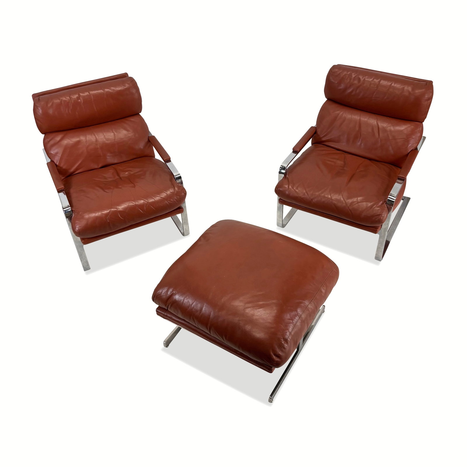 Suite of Mid-Century Modern Lounge Chairs, 3: Suite of mid-century modern lounge chairs, possibly Italian, 1970s, comprising two chrome and leather armchairs and an ottoman. [Chairs: 33" H x 26.5" W x 32" D; Ottoman: 18" H x 31" W x 27" D]. Overa