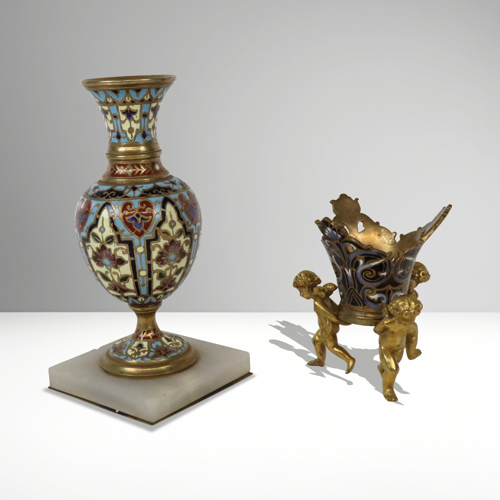 Pair of Champleve Enamel, Onyx & Bronze Bud Vases: Pair of Louis XV gilt bronze, champleve enamel and onyx bud vases, French, probably 20th century, of diminutive form, with elongated necks, and white shoulders supporting playful putto, and resting