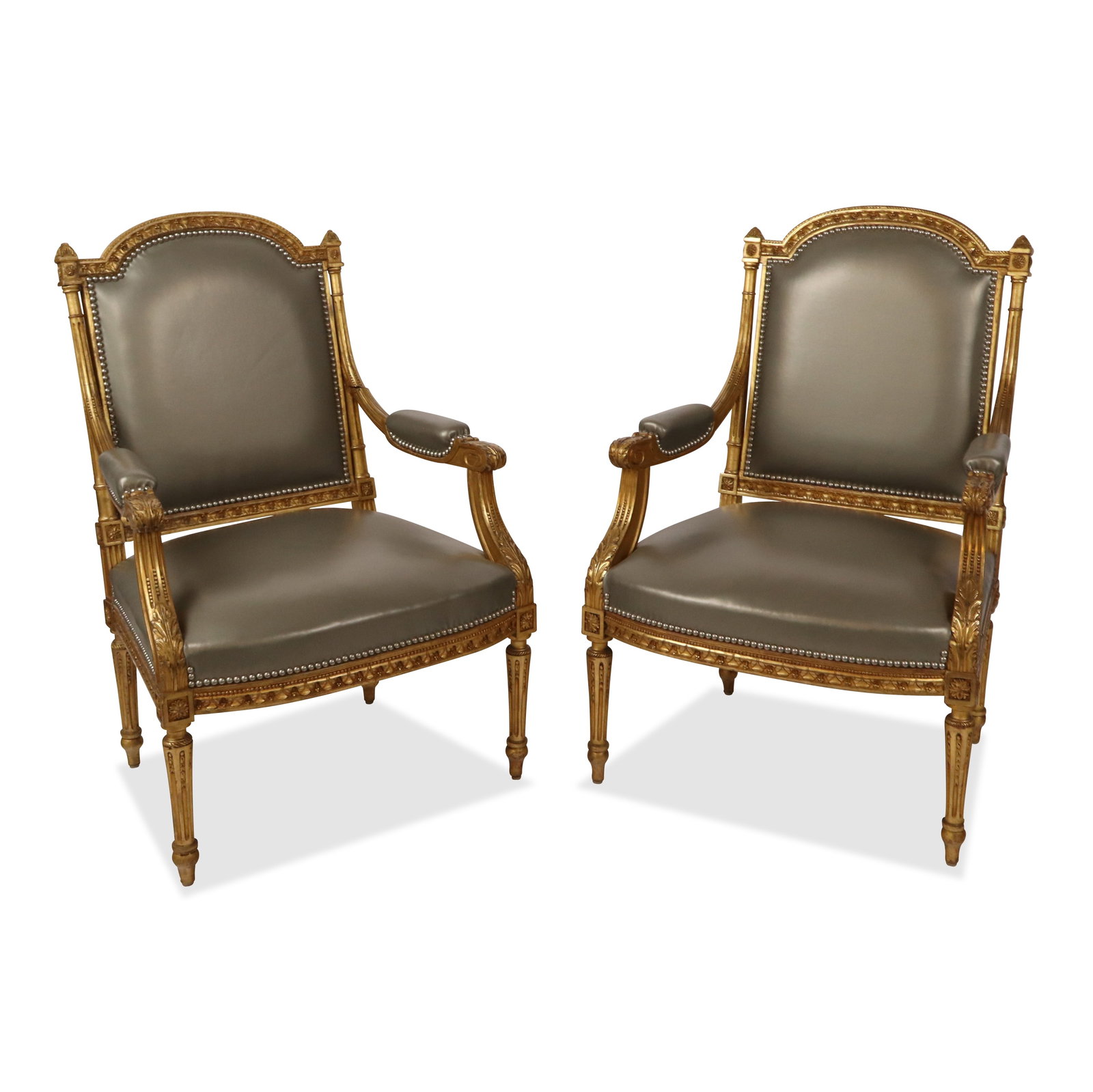 Pair of Louis XVI Leather Upholstered Fauteuils: Pair of Louis XVI fauteuils, 20th century, with carved frames and silver metallic leather upholstery. [40" H x 26" W x 22" D]. Condition to each is good.