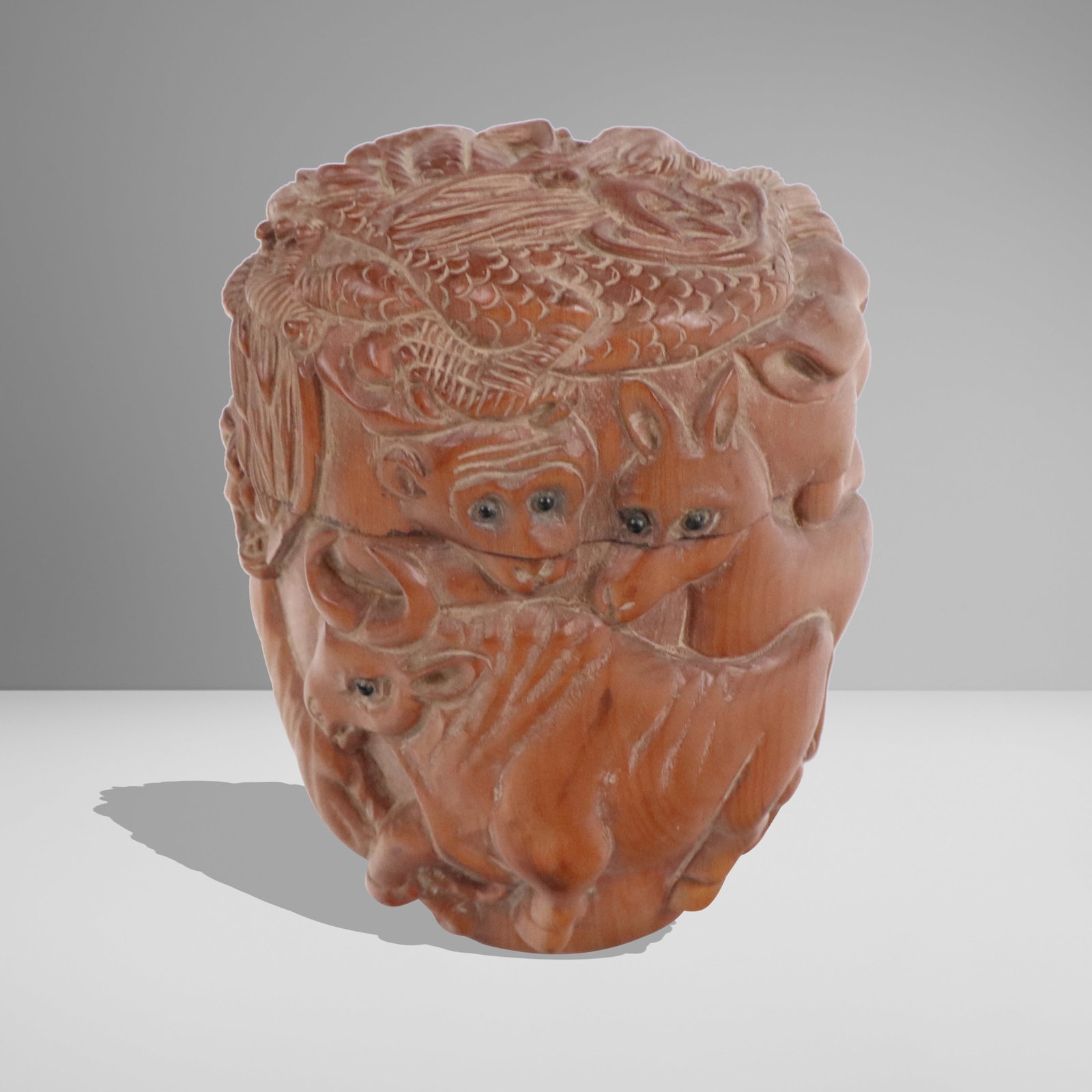 Japanese Carved Wood Box with Animals: Japanese carved wood box, 20th century, with animal and fragon decoration, eyes of inset stone or glass, with a label affixed at base. [3.25" H x 3" Diameter]. Condition is good with some losses to ey