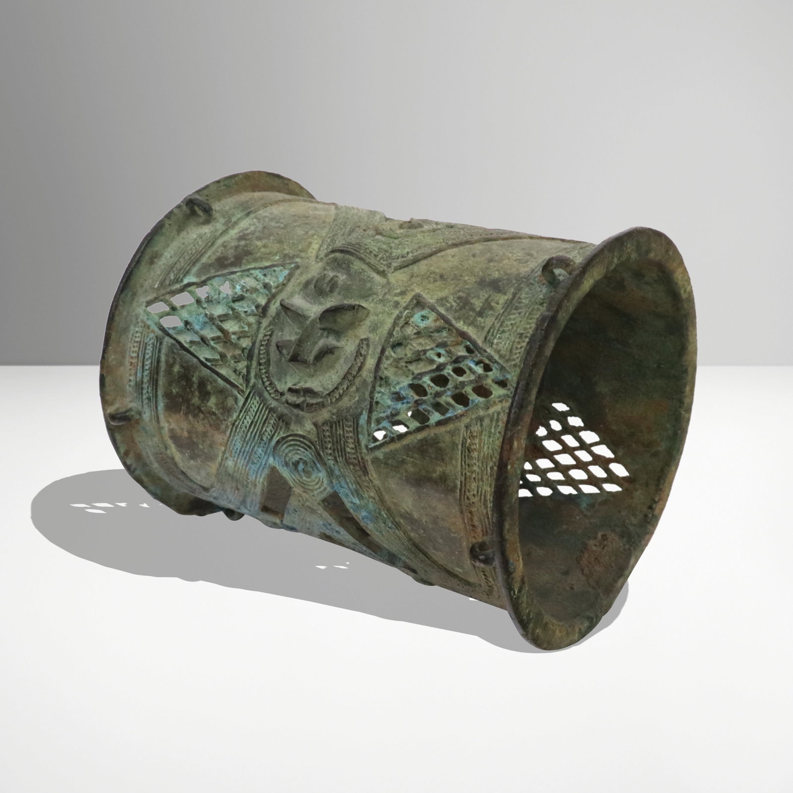 African Nigerian Bronze Patina Armlet: Antique reticulated Nigerian bronze armlet, having iconographic motif, with green patina. Provenance: From the Estate of Dr Robert Reber, Greenwich, CT. [4" H x 3.5" W].