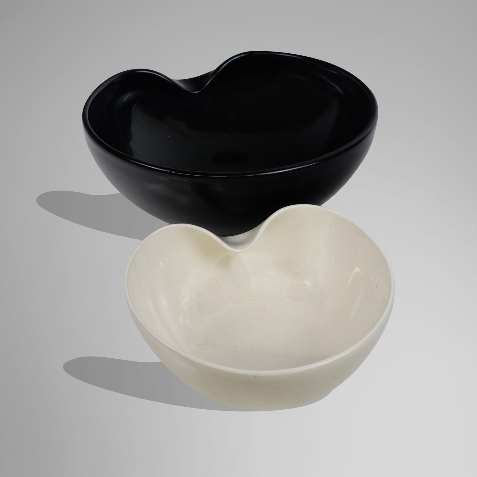 Elsa Peretti for Tiffany & Co. "Thumbnail" Bowls,: Elsa Peretii for Tiffany & Co. two "Thumbnail" bowls, comprising a white porcelain example [3.5" H x 7.5" Diameter], and an opaque black glass example [4.5" H x 11.25" Diameter], marks to underside of