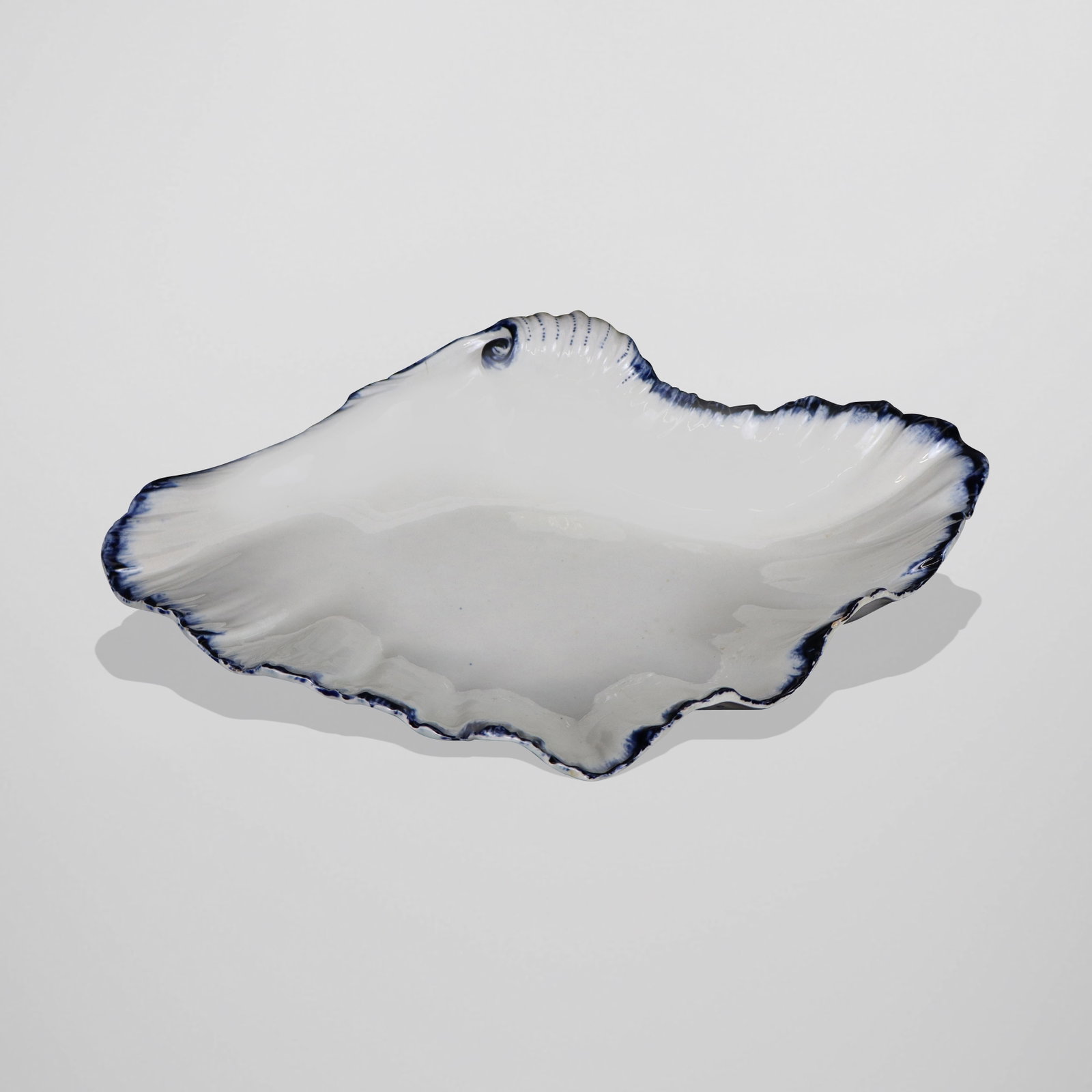 Wedgwood Early Shell Dish: Wedgwood early white and blue decorated shell dish, English, probably early 19th century, mark to underside with impressed Wedgwood C. [2.25" H x 11" W x 7" W]. Overall condition is good, small