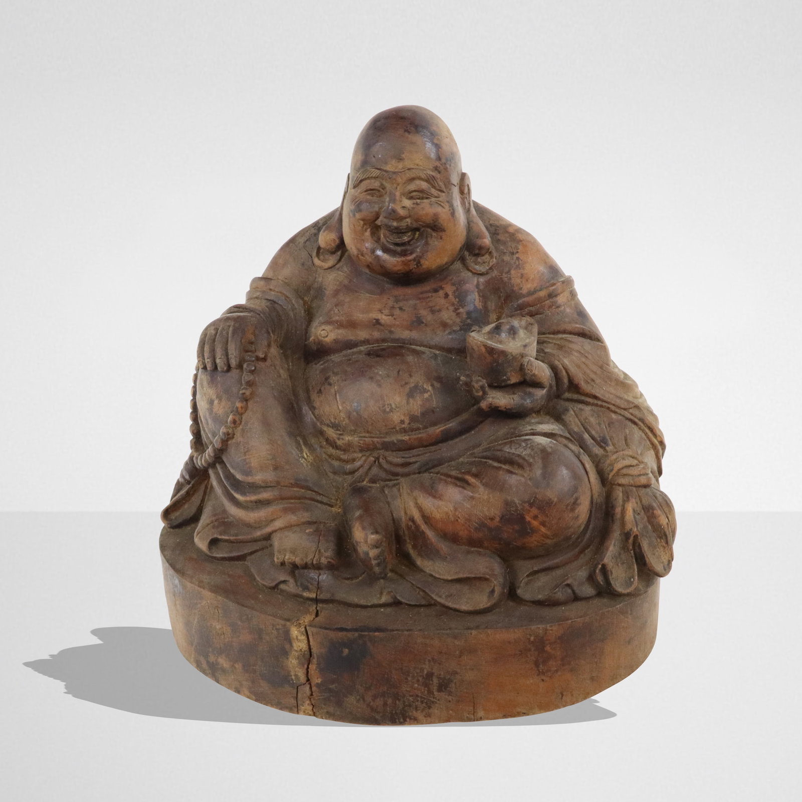 Carved Wood Figure of a Laughing Buddha: Carved wood figure of a laughing Buddha, 19th to early 20th century. [8.5" H x 8.5" W x 8" D]. Condition is good with age-commensurate cracks to wood and surface wear.