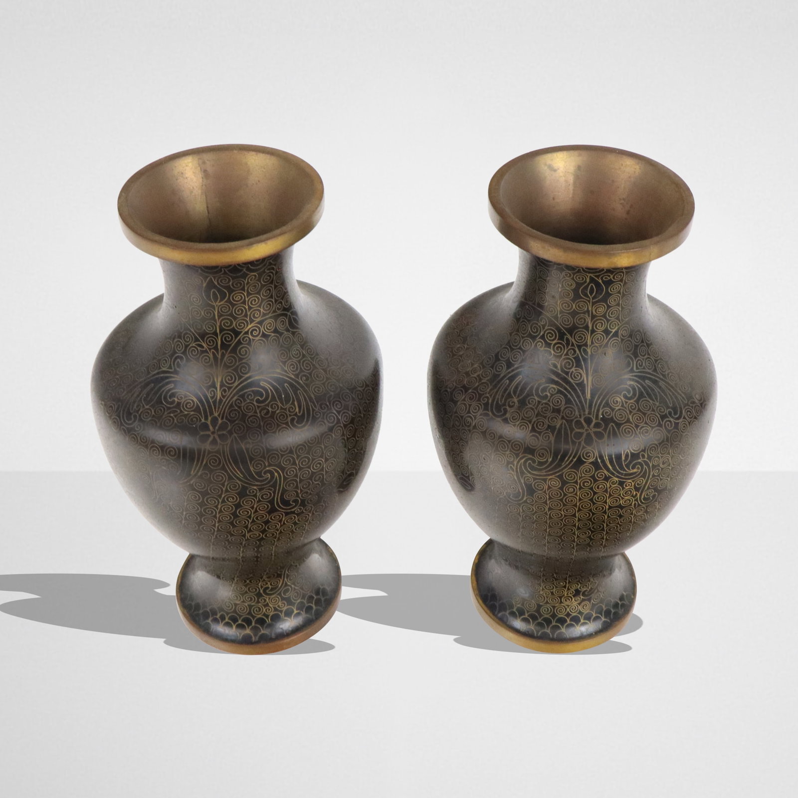 Pair of Chinese Black Cloisonne Vases: Pair of Chinese black enameled cloisonne vases, 20th century, with scrolled floral decoration, unmarked to bases. [6.75" H x 3.75" Diameter]. Condition to each is good.