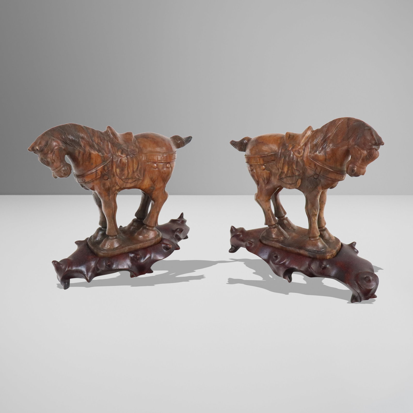 Pair of Chinese Carved Stone Horses on Stands: Pair of Chinese carved stone horses, later 20th century, on carved wood stands. [6.5" H x 6" W x 3" D]. Condition is good.