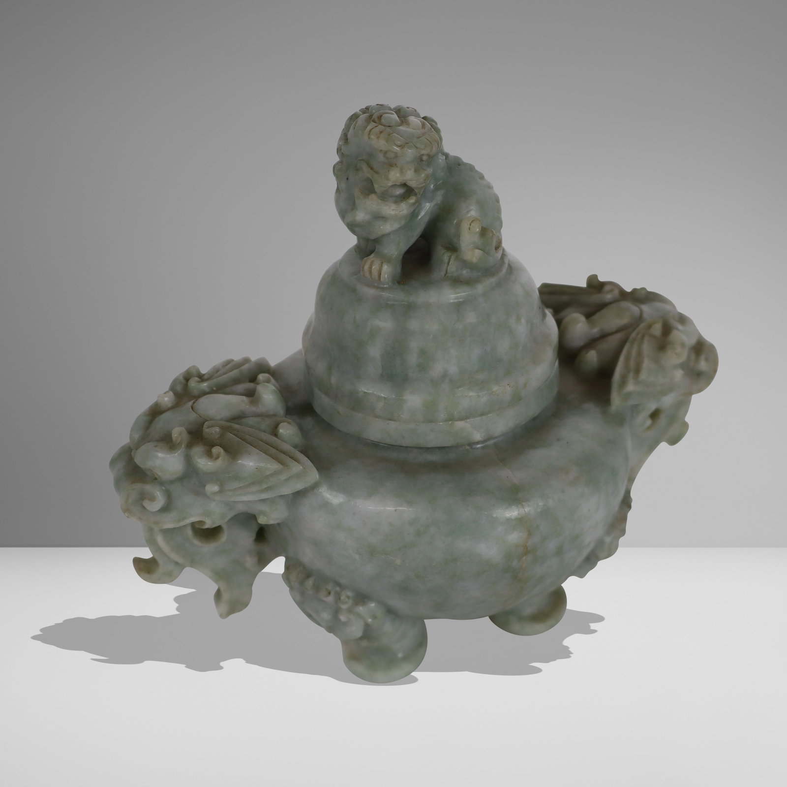 Chinese Carved Jade Censer: Chinese carved jade censer, 20thc entury, with two figural handles and a foo dog finial. [6.75" H x 7.5" W x 4.25" D]. Condition is good with some wear.