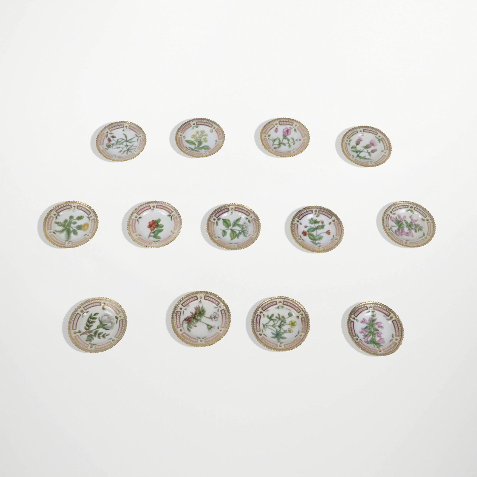 Royal Copenhagen "Flora Danica" Butter Pats, 13: Royal Copenhagen "Flora Danica" pattern butter pats, marks to underside of base. [3" Diameter]. Overall condition is good.