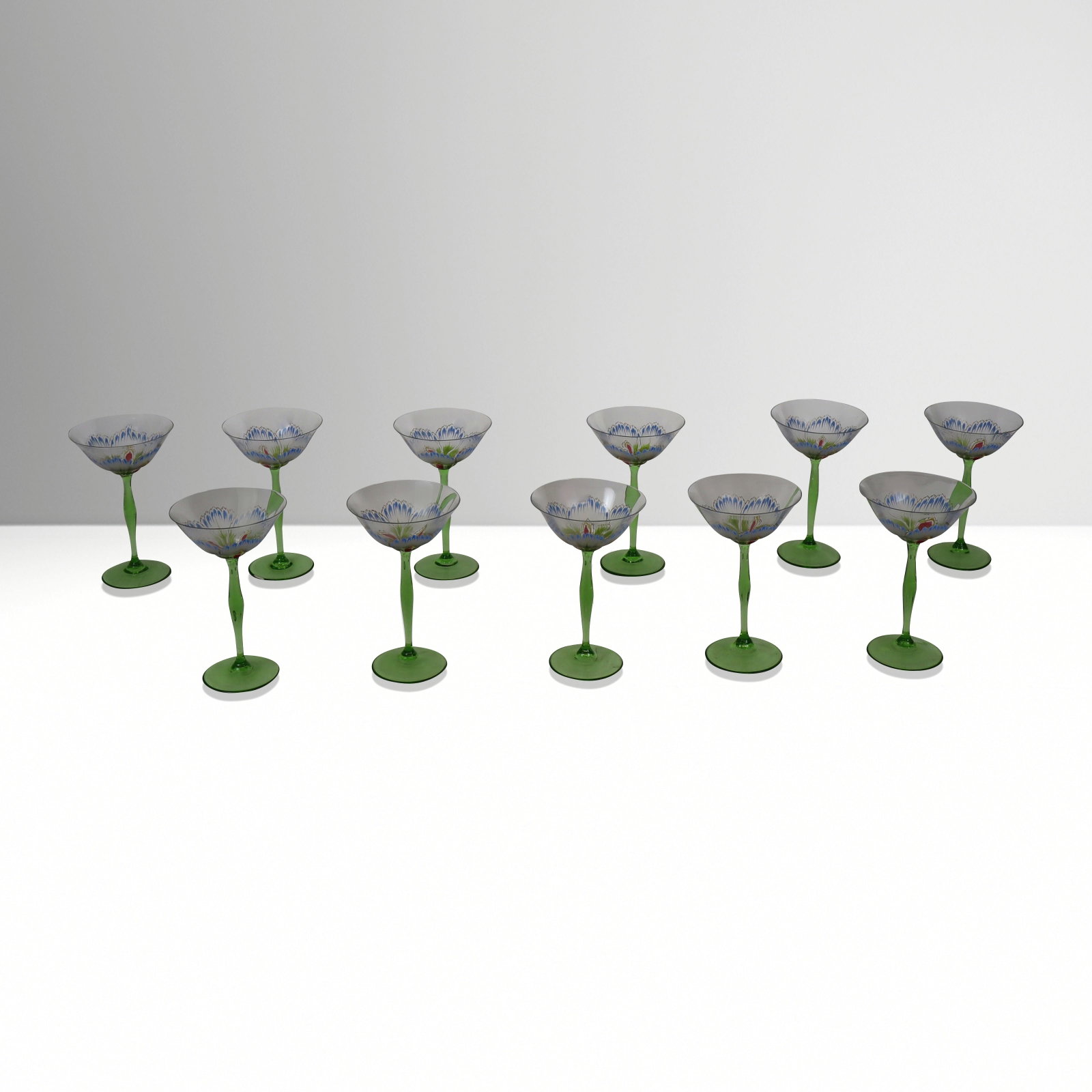 Theresienthal Hand-Painted Champagne Saucers, 11: Theresienthal set of eleven art nouveau inspired hand-painted champagne saucers, probably Germany, each bowl decorated as a flower head, resting on a green glass stem, unmarked. [7.25" h X 2.75" Diame