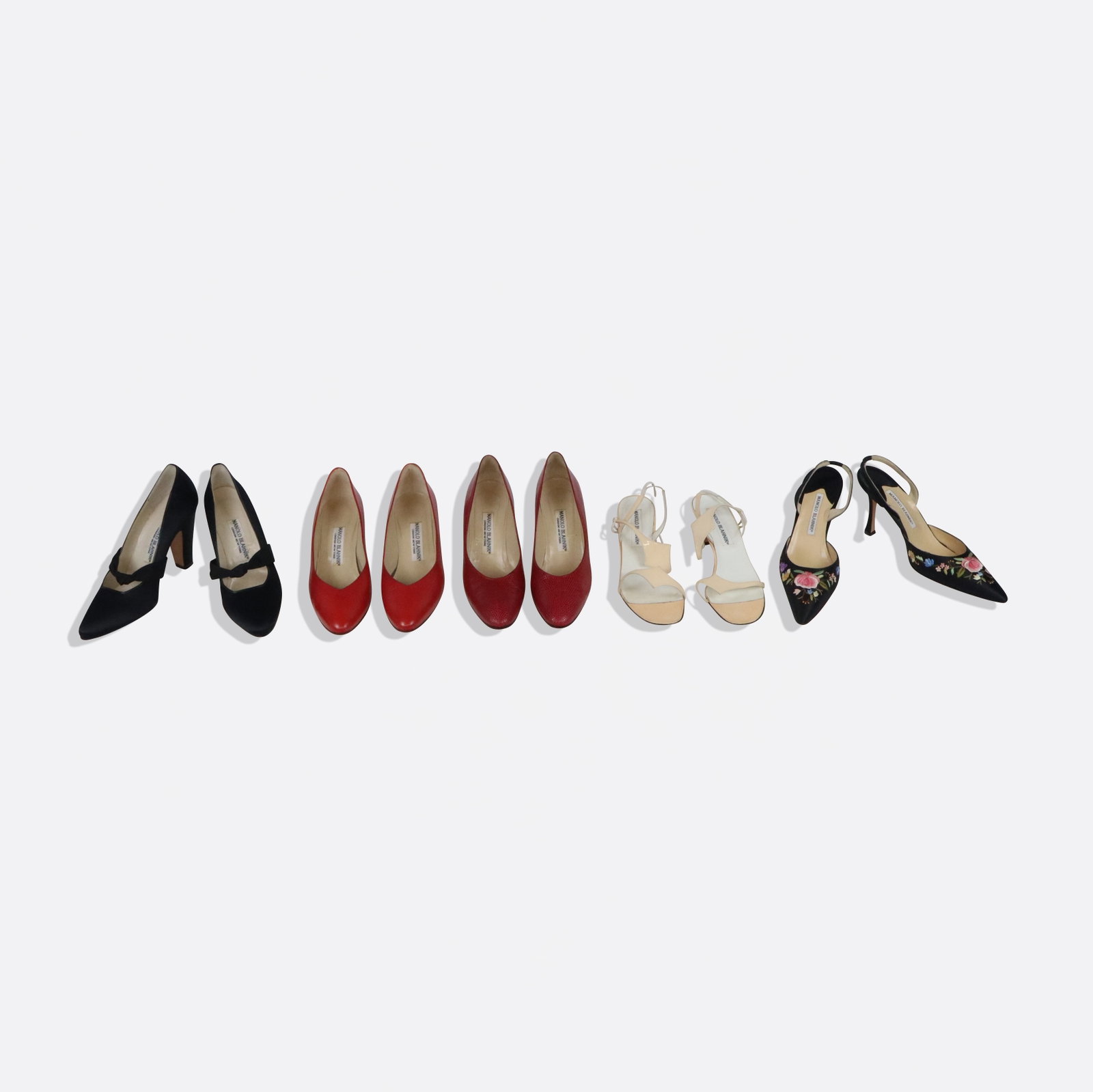 Assorted Manolo Blahnik Heels and Pumps, 5: Assorted Manolo Blahnik heels comprising a pair of floral embroidered slingback heels, a pair of red leather pumps, a pair of red lizard skin pumps, a pair of black silk heels with bow detail, and a p