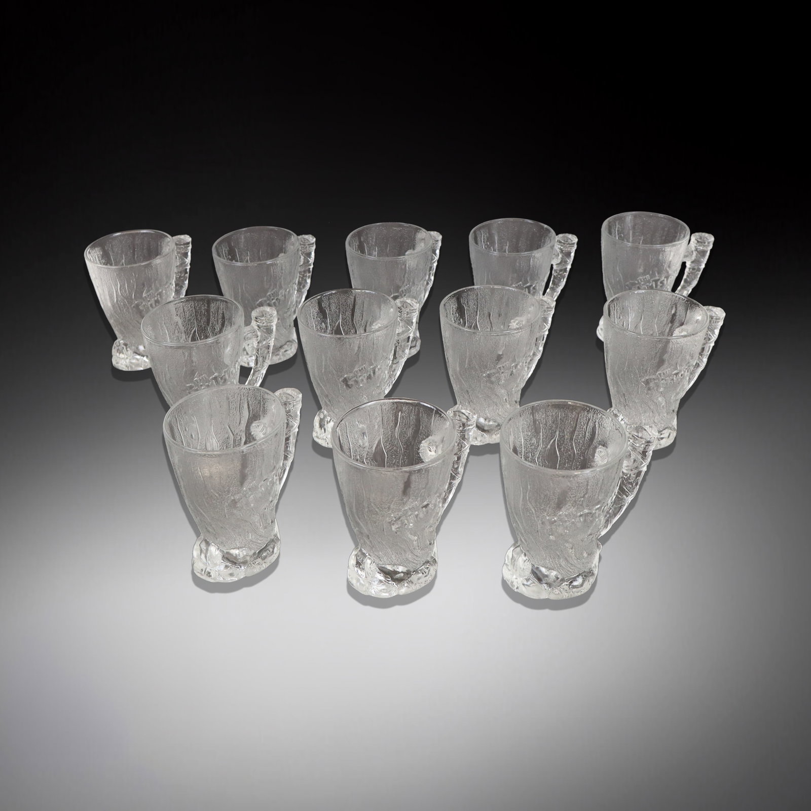 McDonalds "Flintstone" Glass Mugs, 16: McDonalds collection of twelve whimsical "Flintstone" molded glass mugs. [4.5" H x 4.5" W x 3" D]. Overall condition is good.