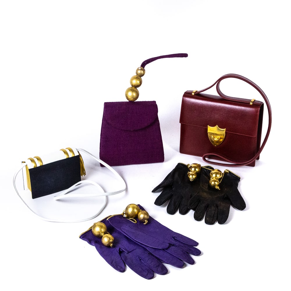 Paloma Picasso Three Handbags & Gloves: Two handbags by Paloma Picasso comprising a red textured leather handbag with gold tone details and a button clasp, marked Paloma Picasso to clasp, a gold and white leather handbag in the shape of a b