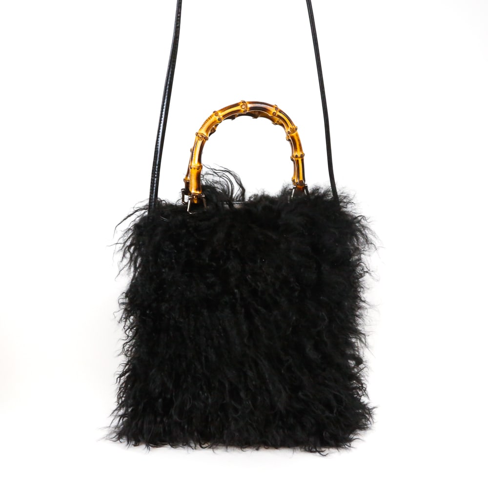 Gucci Mongolian Lamb Handbag with Bamboo Handle: Gucci Mongolian Lambo shearling handbag, 21st century, with a bamboo handle and leather strap and leather lining, marked Gucci Made in Italy to interior label, with dustbag. [Less strap and handles: 1