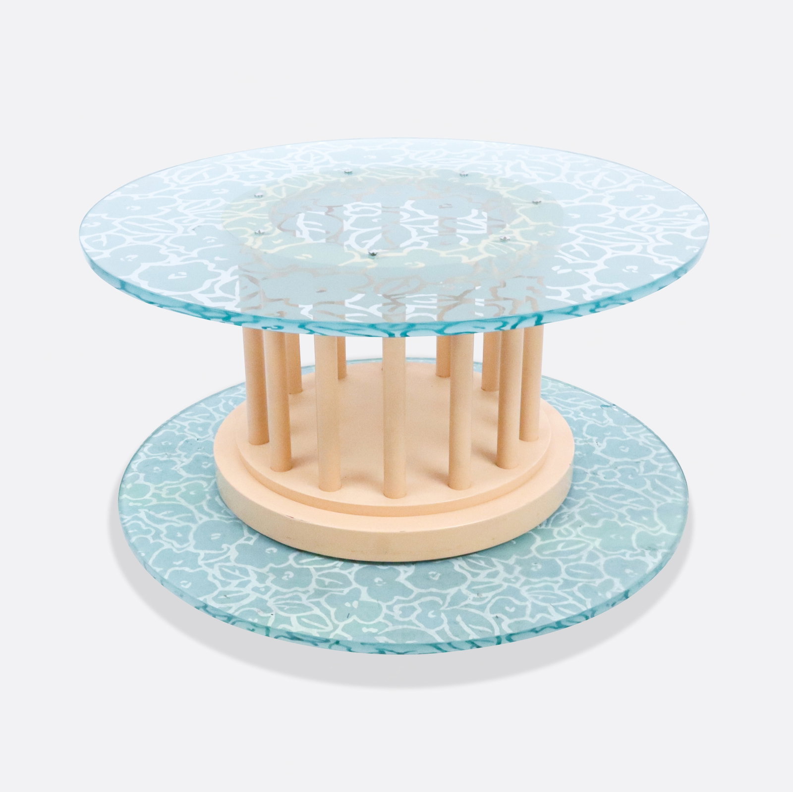 Michael Graves Circular Coffee Table: Contemporary coffee table with an incised Cottage Garden pattern to glass top above a creme painted stepped base with column support. [17.25" H x 36" Diameter]. Condition is good with some wear to bas